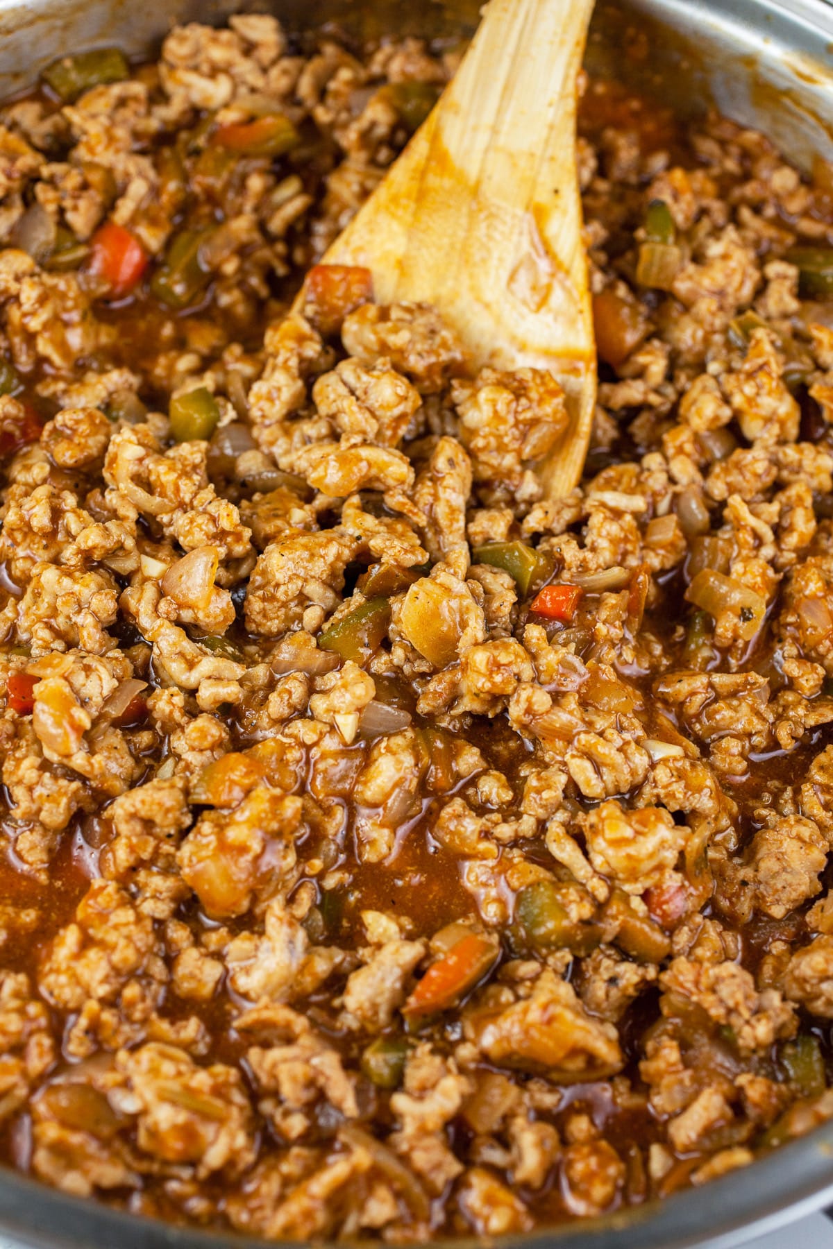 BBQ chicken sloppy joes in skillet with wooden spoon.