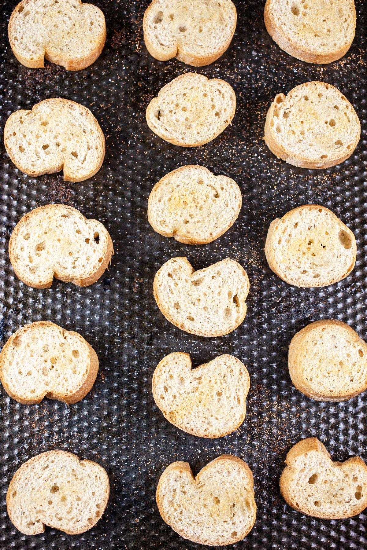 Toasted crostini on sheet pan.