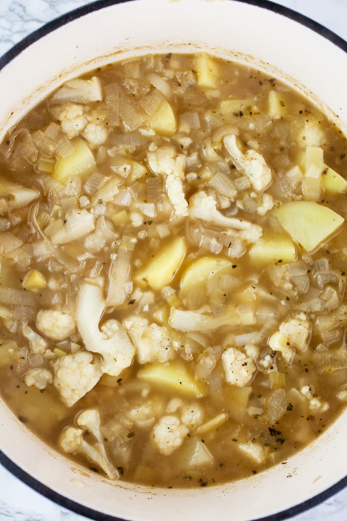 Chunky potato leek cauliflower soup in Dutch oven.