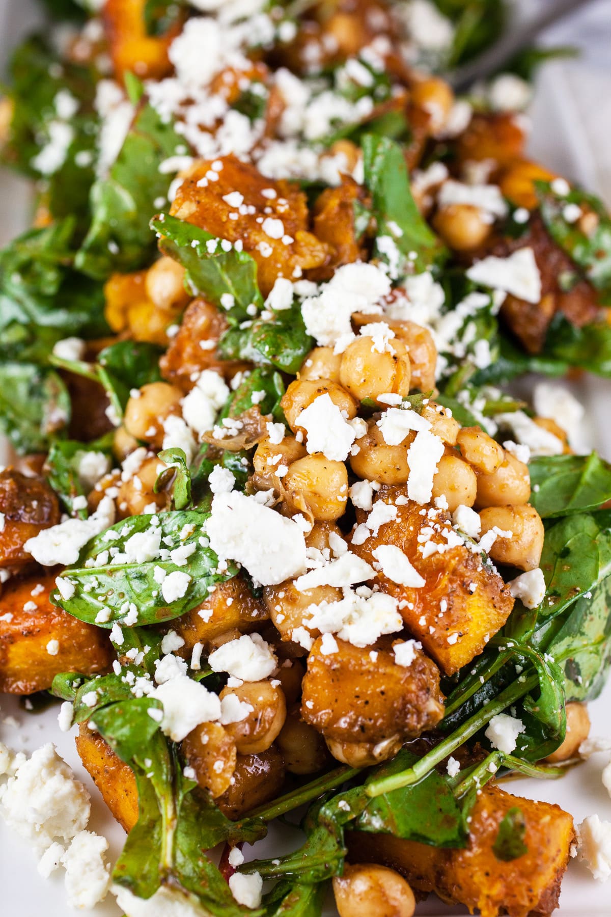 Roasted pumpkin chickpea feta salad on white serving platter.