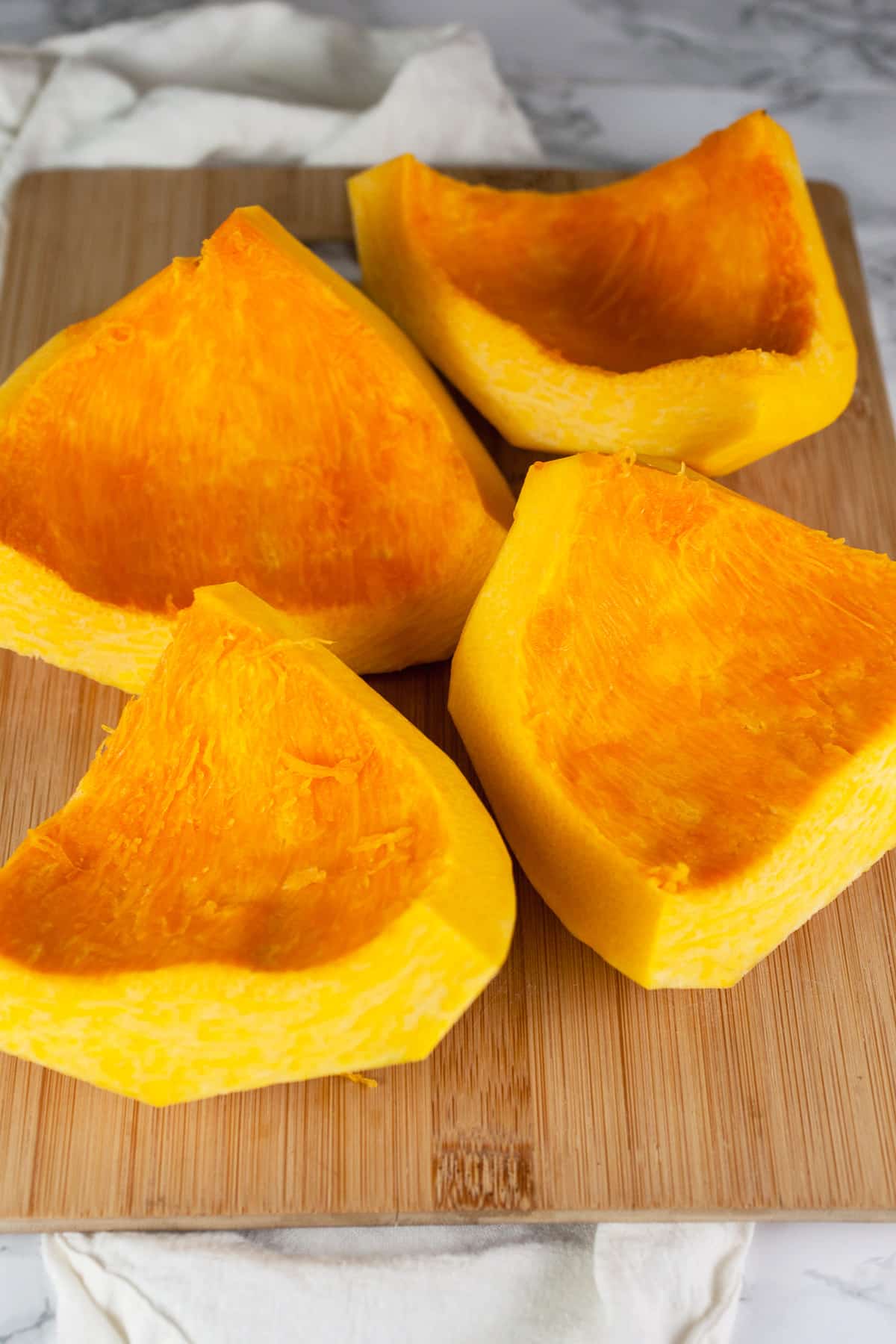 Peeled pumpkin half cut into quarters.