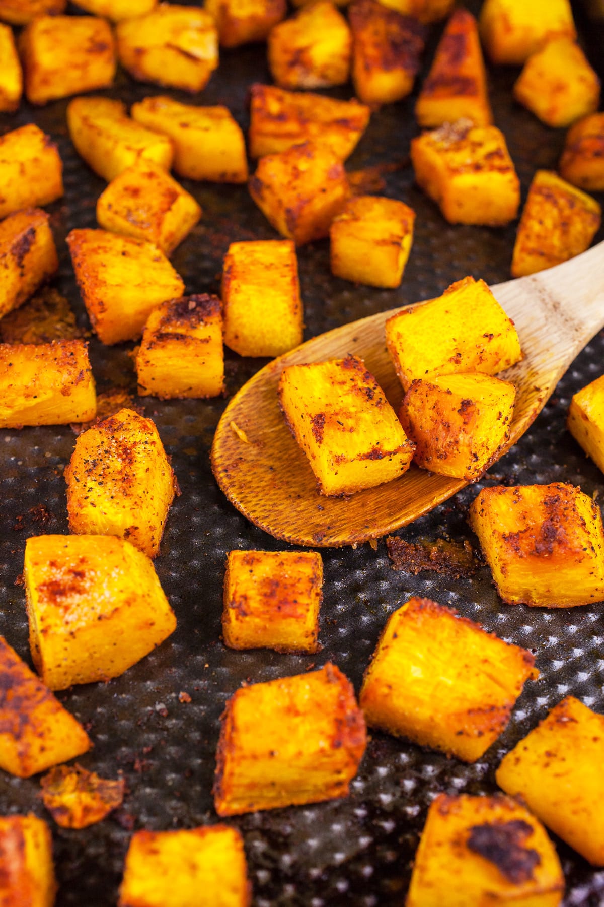 Roasted pumpkin with spices on baking sheet.