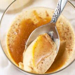 Pumpkin panna cotta with salted caramel sauce in glass with spoon.