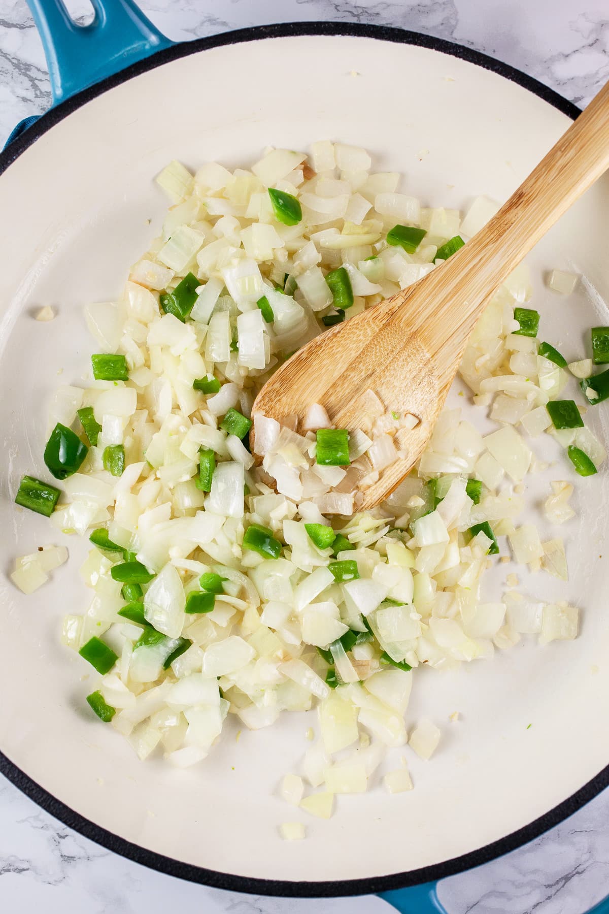 Garlic, onions, and jalapeno pepper sautéed in skillet. 