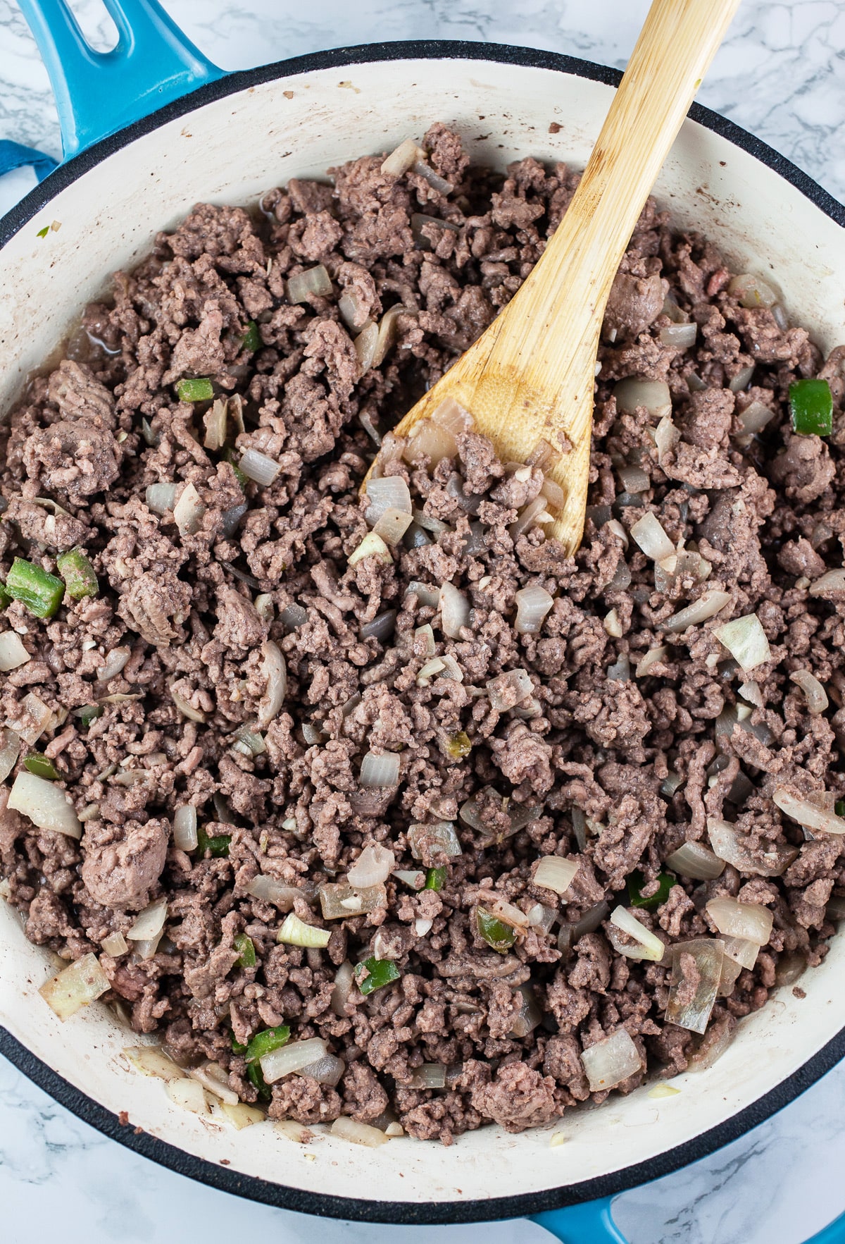 Ground beef, garlic, onions, and jalapeno peppers sautéed in skillet. 