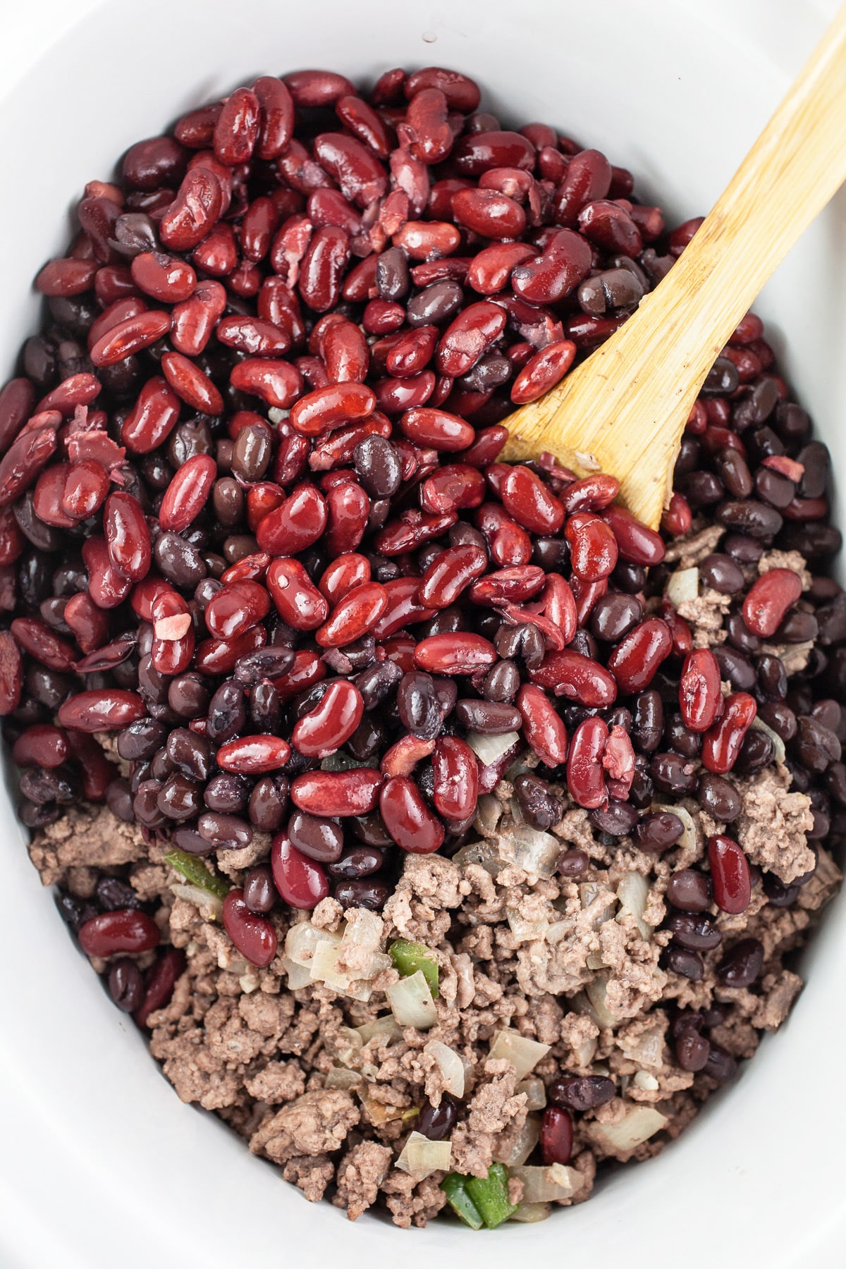 Ground beef, kidney beans, and black beans in slow cooker.