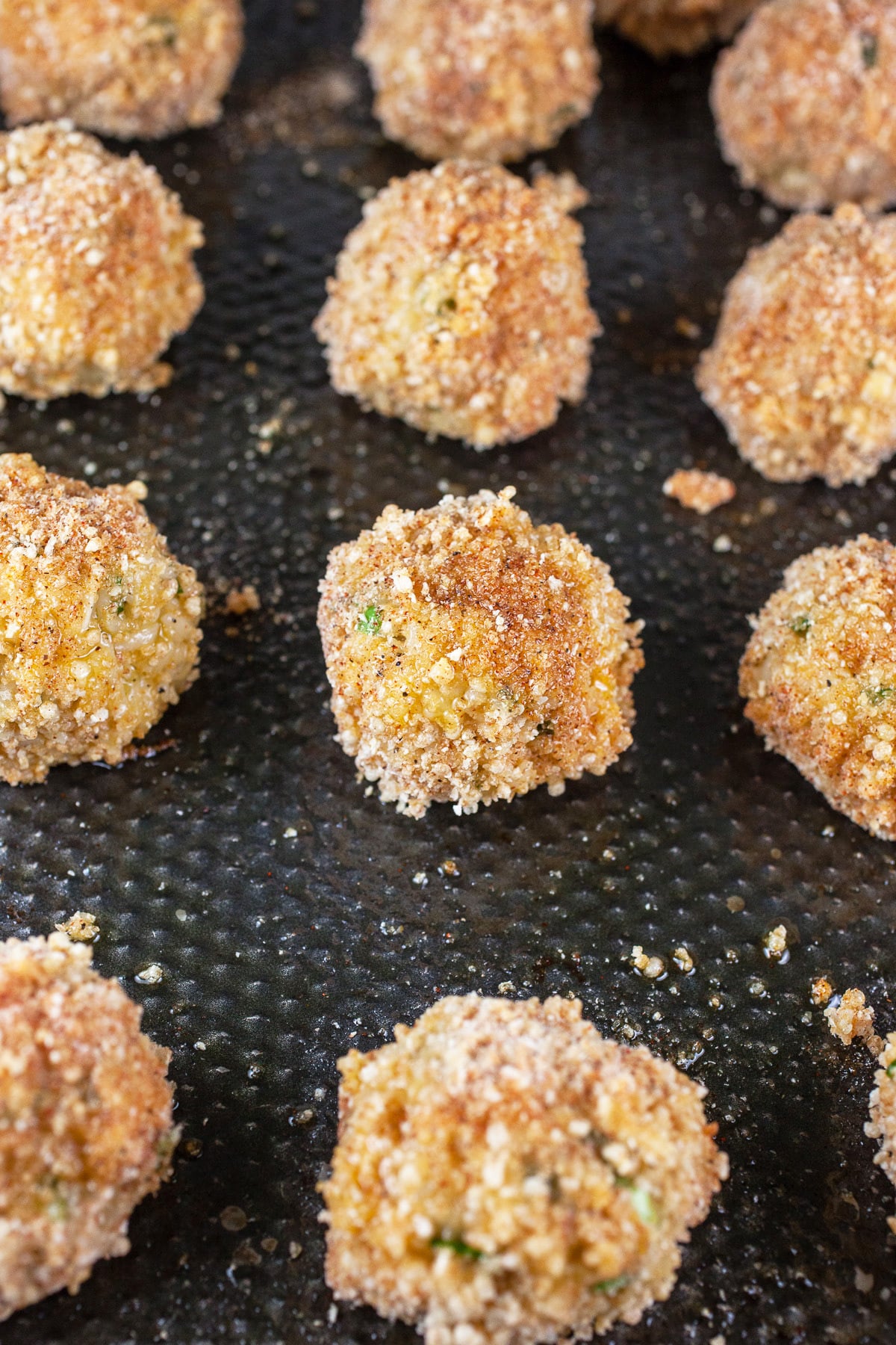 Uncooked rice balls on sheet pan.