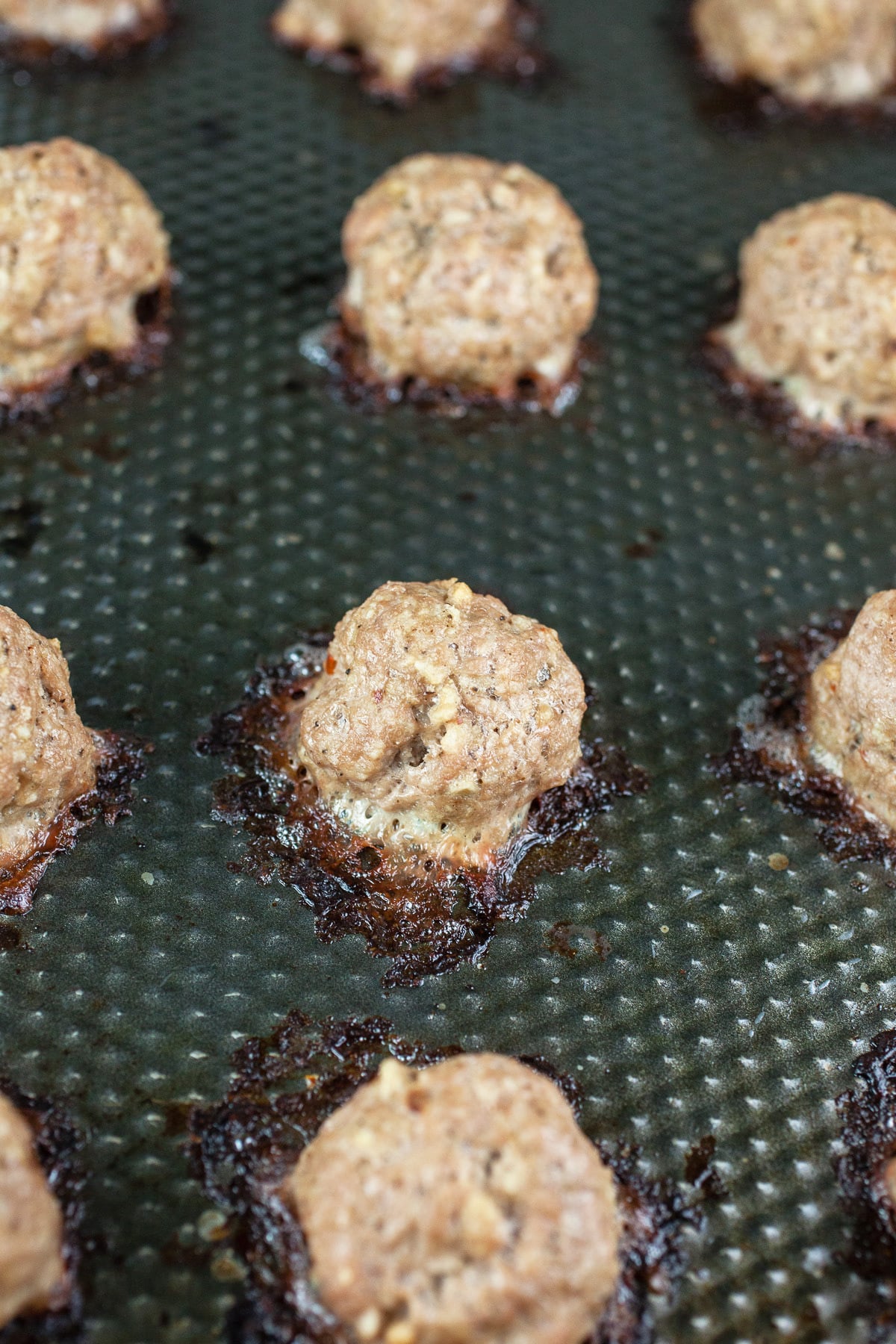 Cooked turkey meatballs on baking sheet.