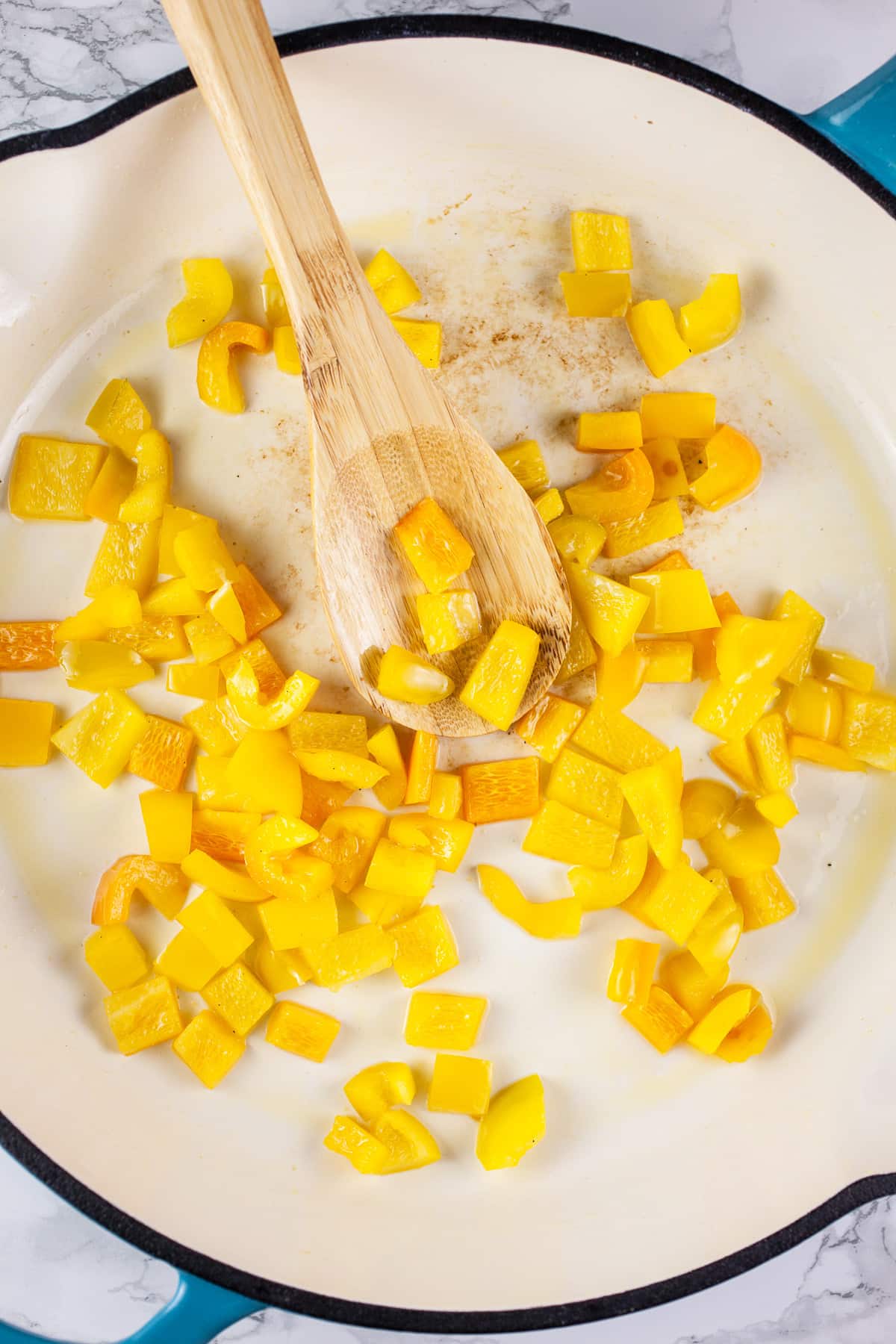 Diced yellow bell peppers sautéed in cast iron skillet.