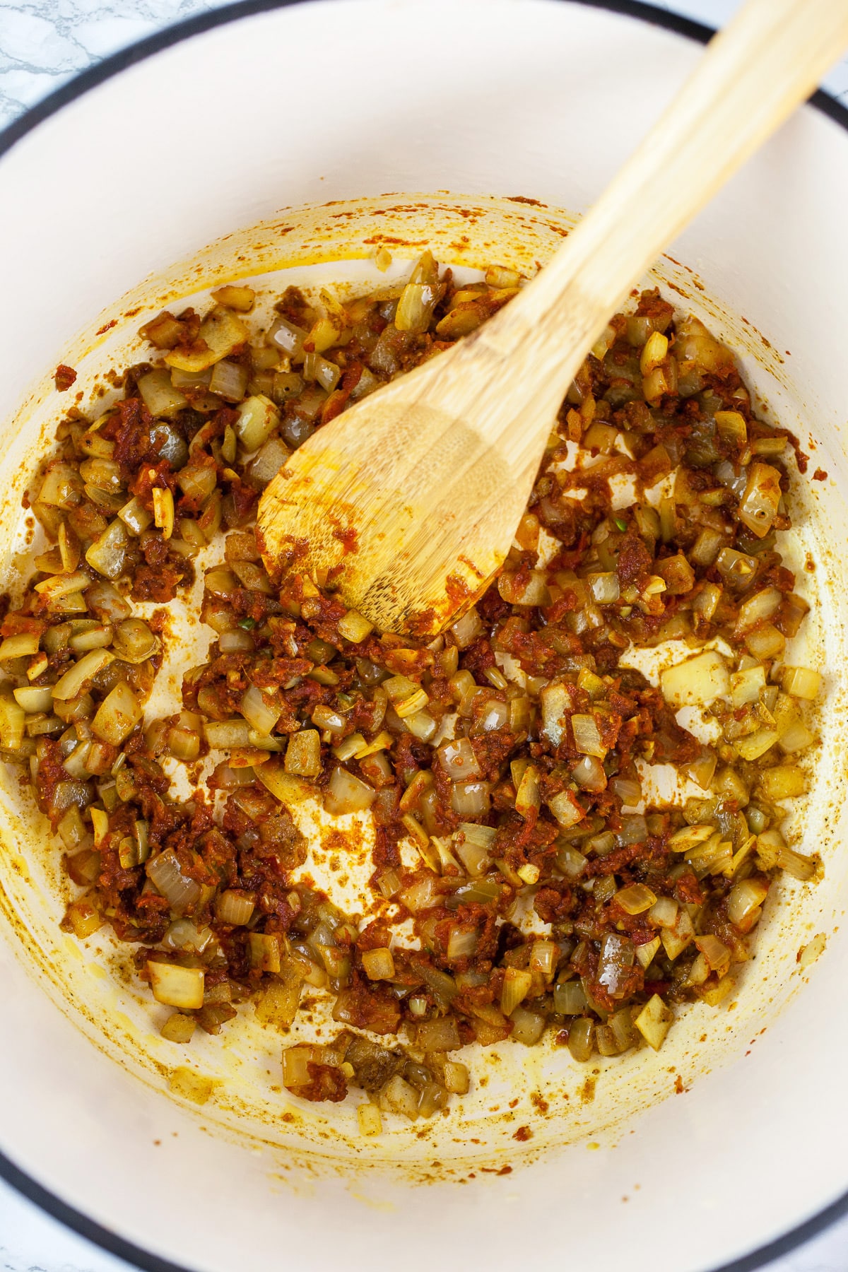 Minced garlic, onions, ginger, spices, and tomato paste sautéed in Dutch oven.