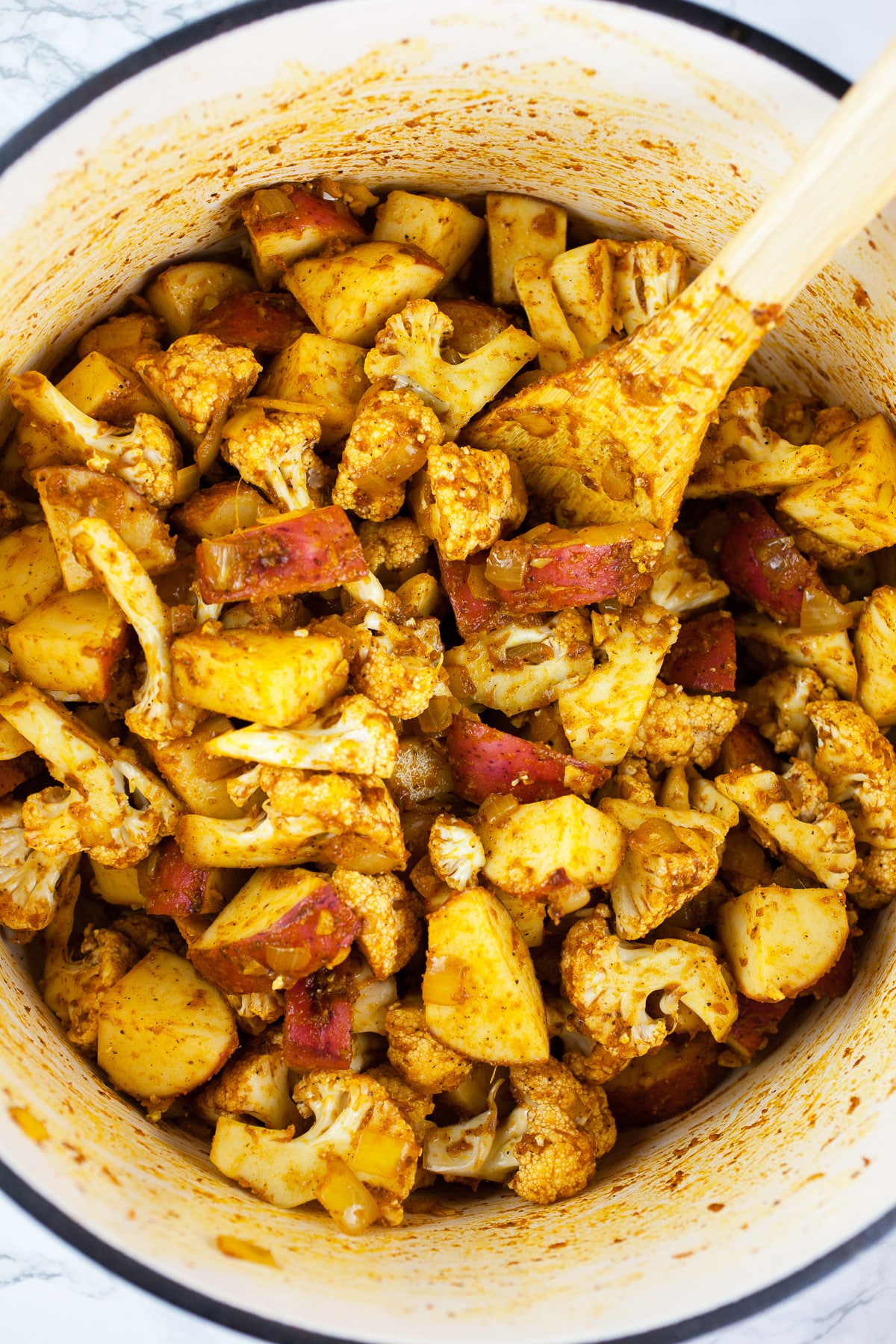 Potatoes, cauliflower, and spices sautéed in Dutch oven.