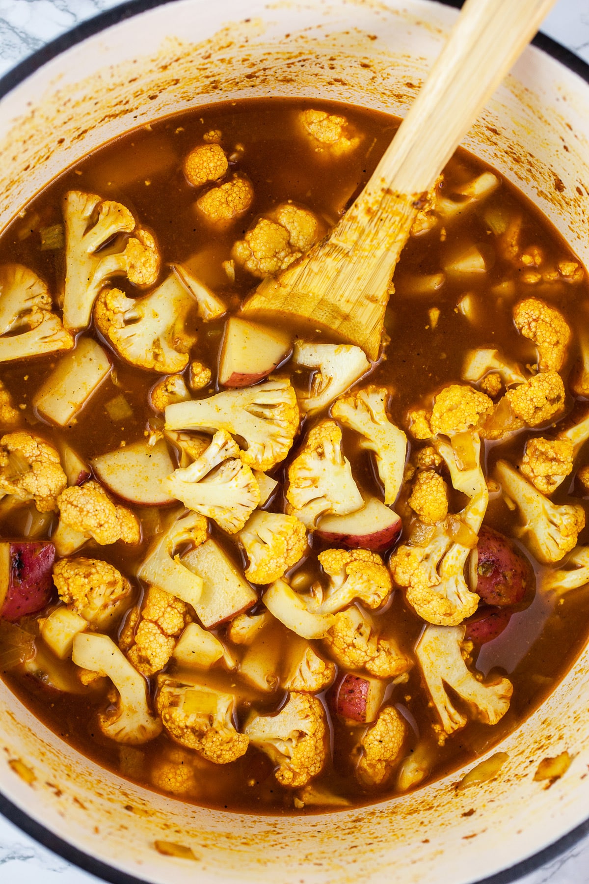 Cauliflower, potatoes, and broth in Dutch oven.