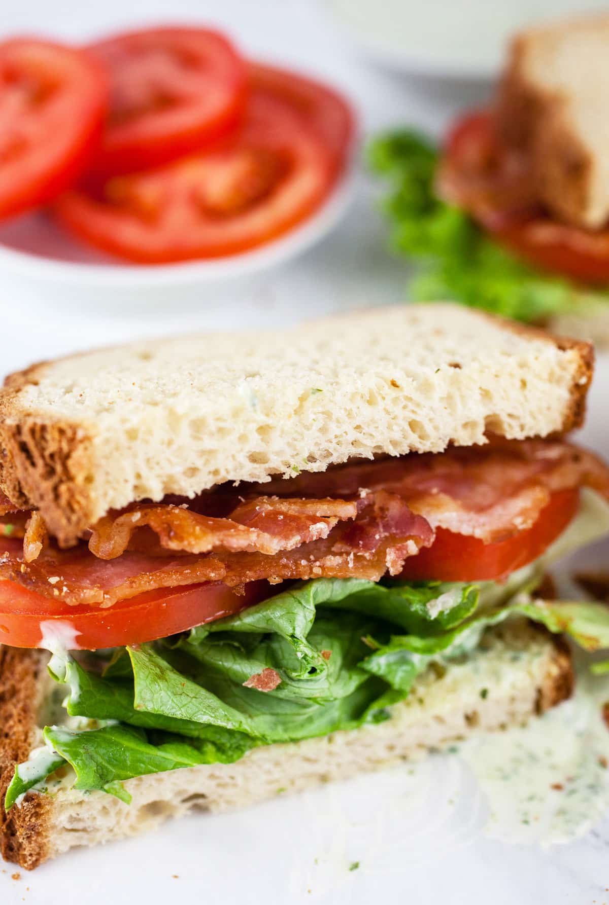 BLT sandwich with lemon basil mayo cut in half.