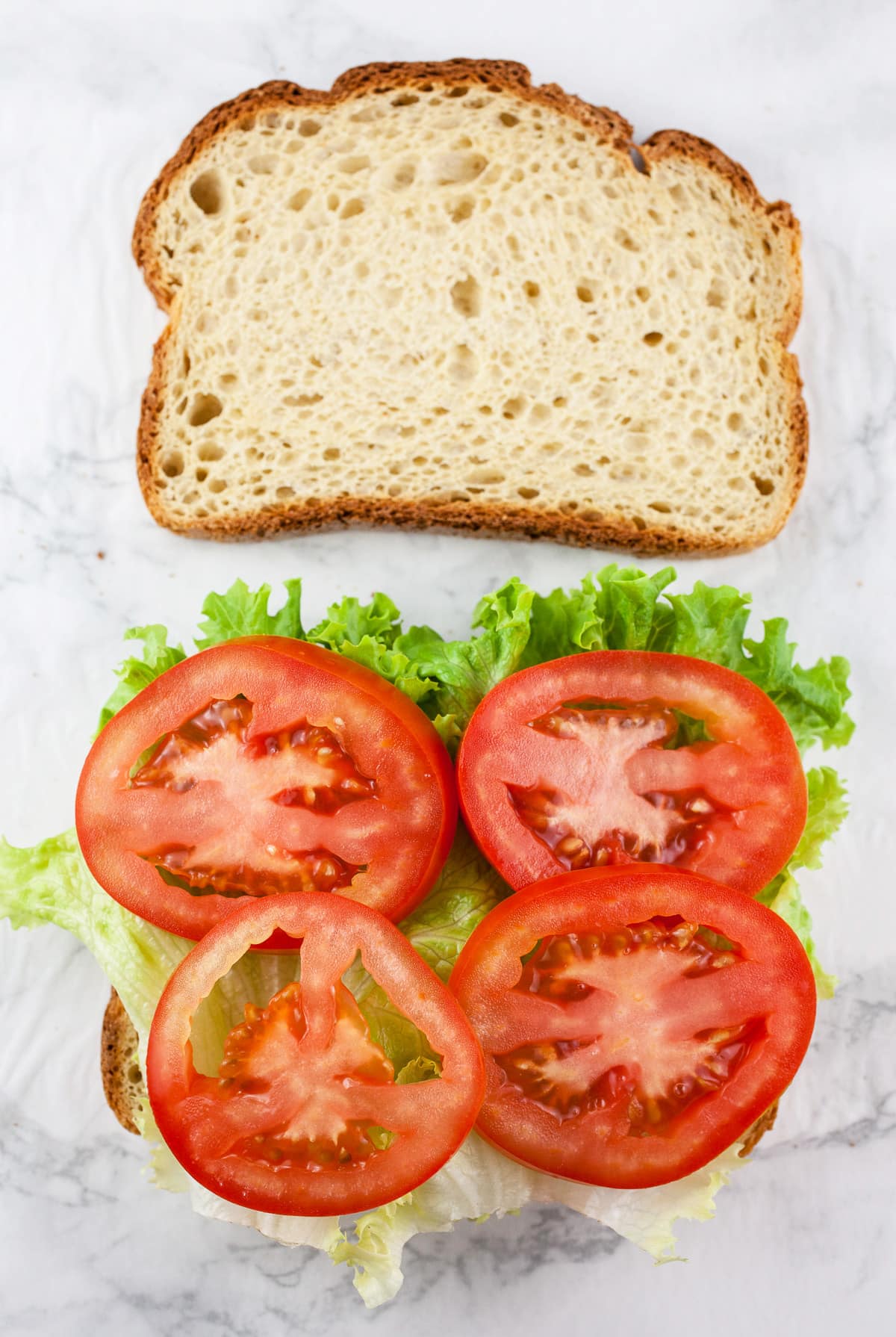 Bread slices with lettuce and sliced tomatoes.