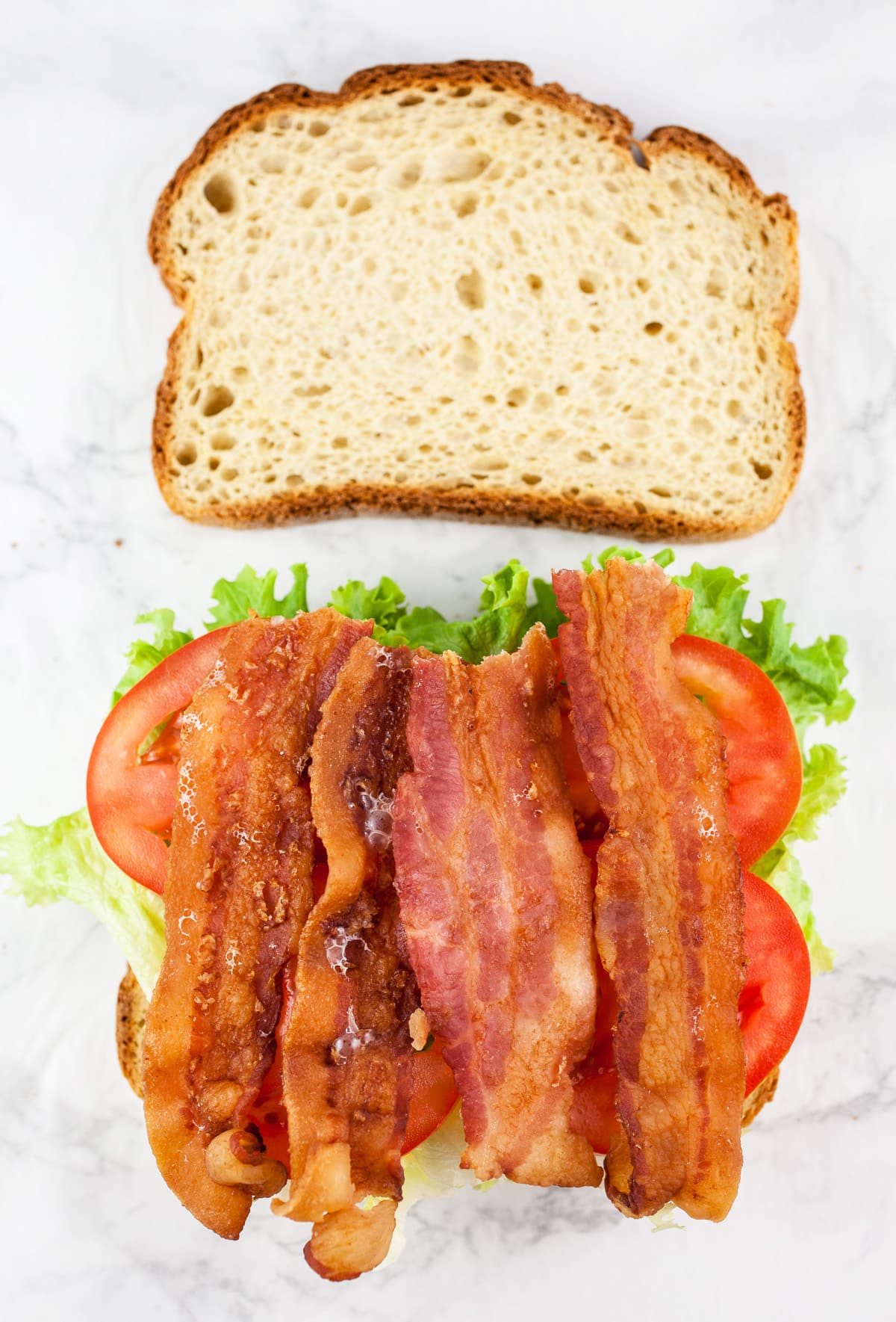 Bread slices with lettuce, tomatoes, and bacon.