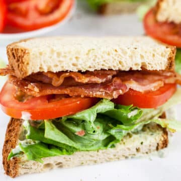 BLT sandwich with lemon basil mayo cut in half.