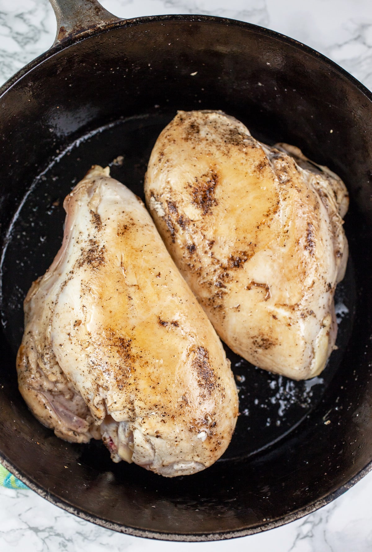 Split chicken breasts sautéed in cast iron Dutch oven.