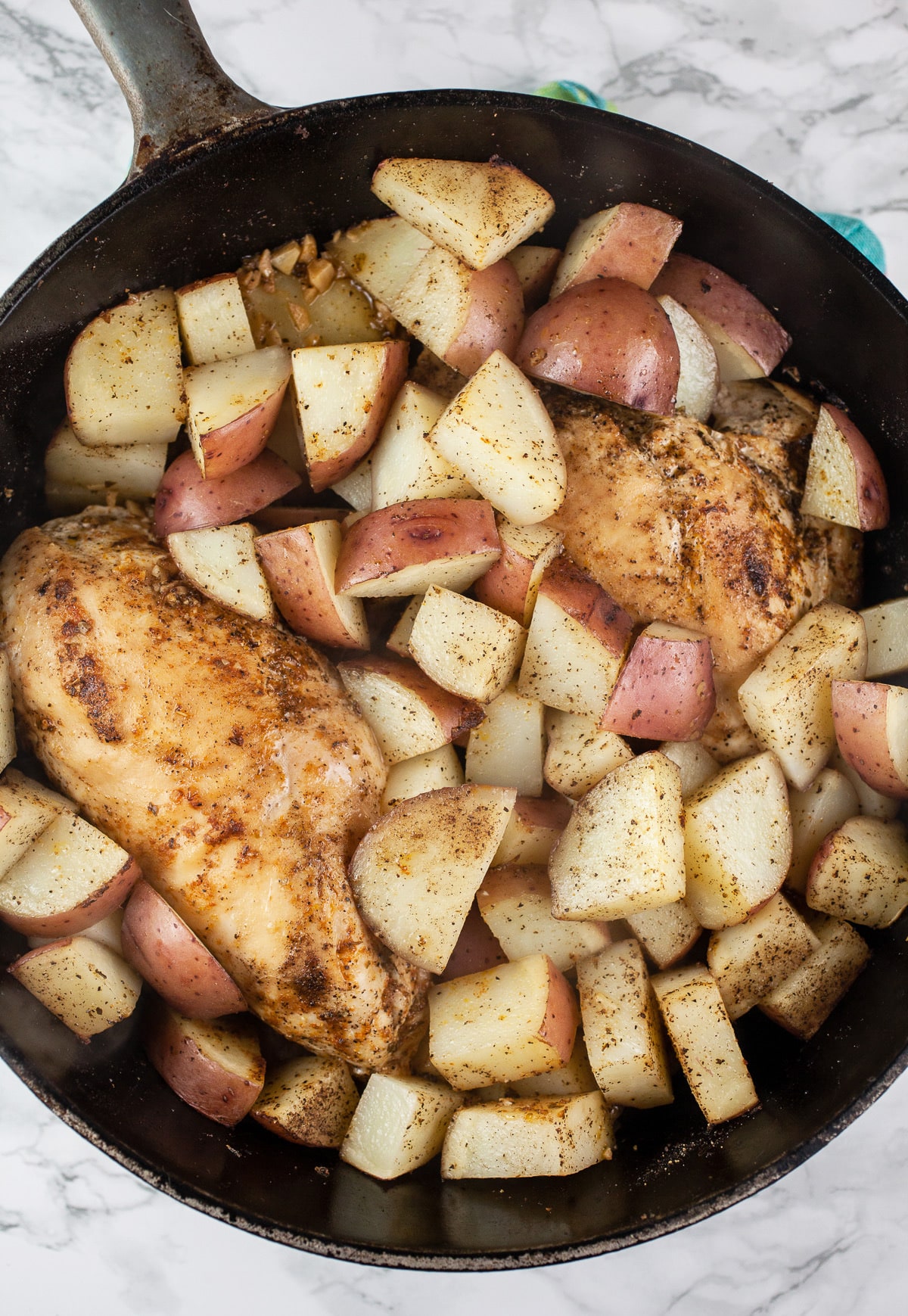Cooked chicken breasts and red potatoes in Dutch oven.