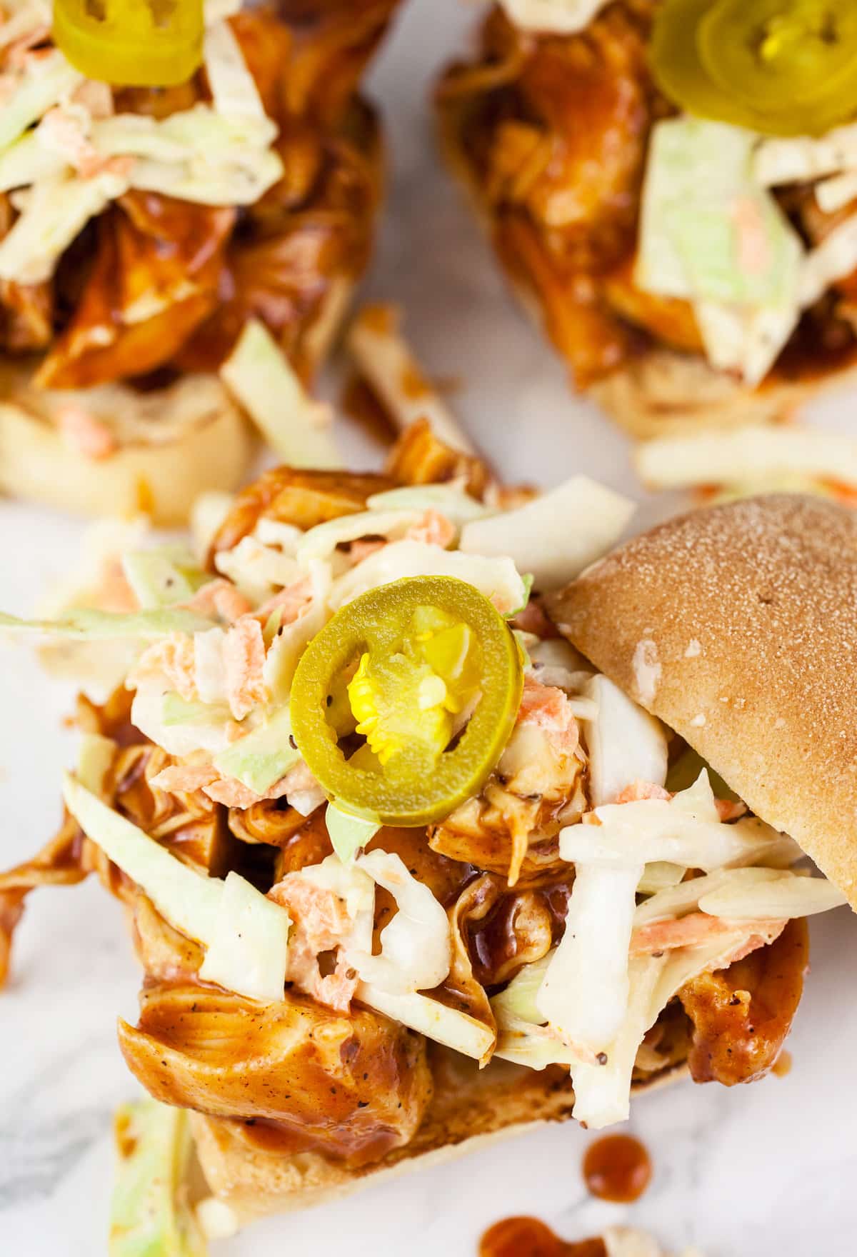 BBQ chicken sandwiches with coleslaw and pickled jalapenos.