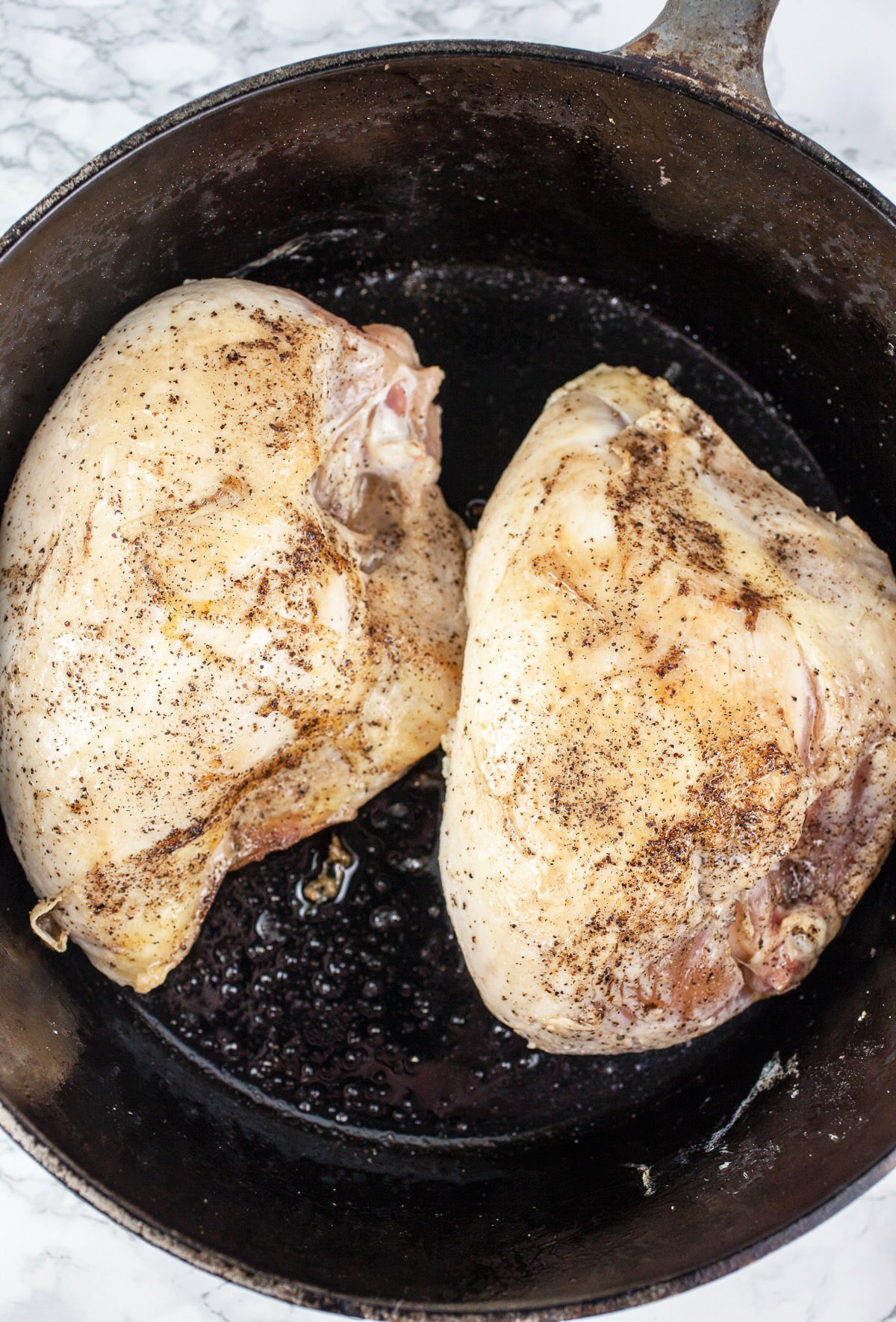 Split chicken breasts sautéed in Dutch oven. 