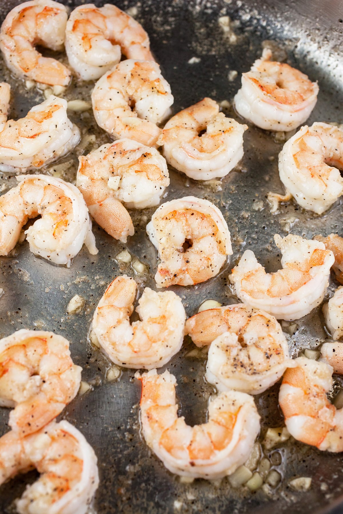 Shrimp sautéed with garlic in skillet.