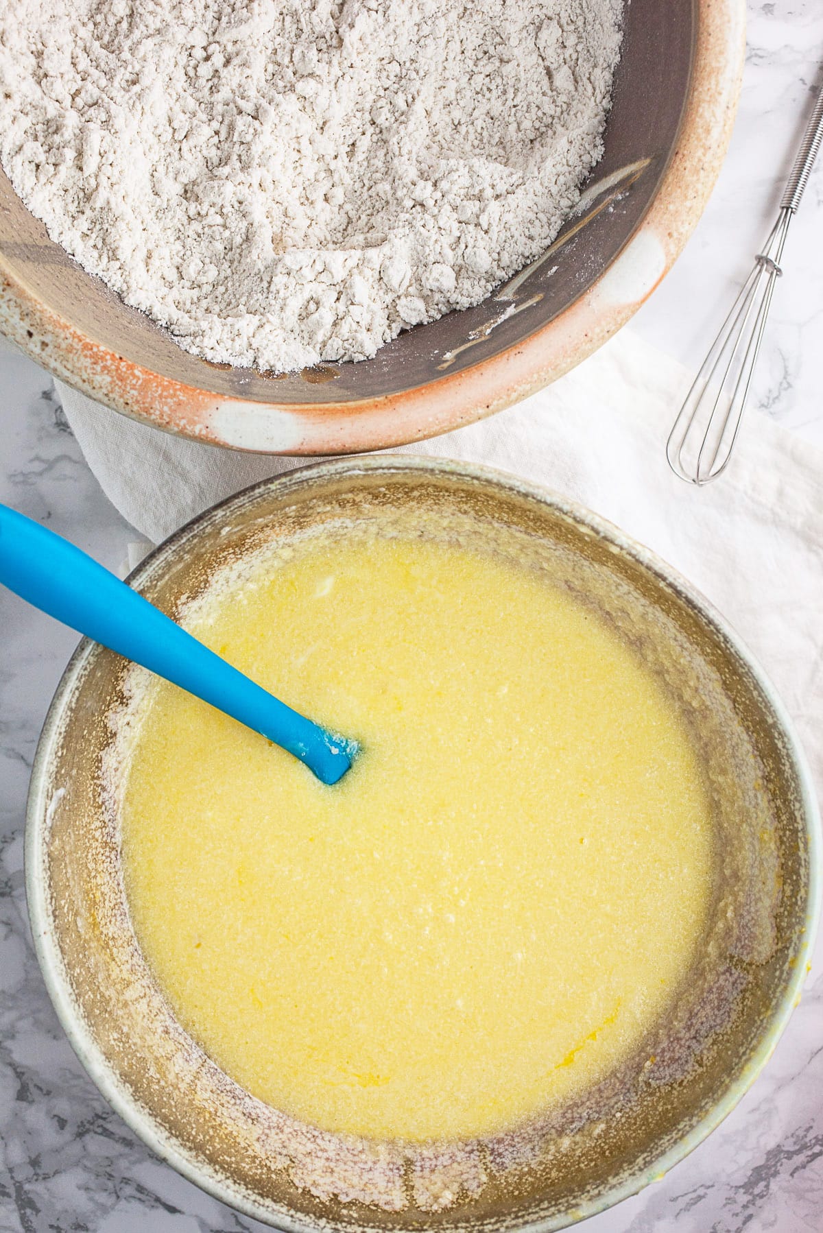 Wet and dry muffin ingredients in two separate ceramic bowls.