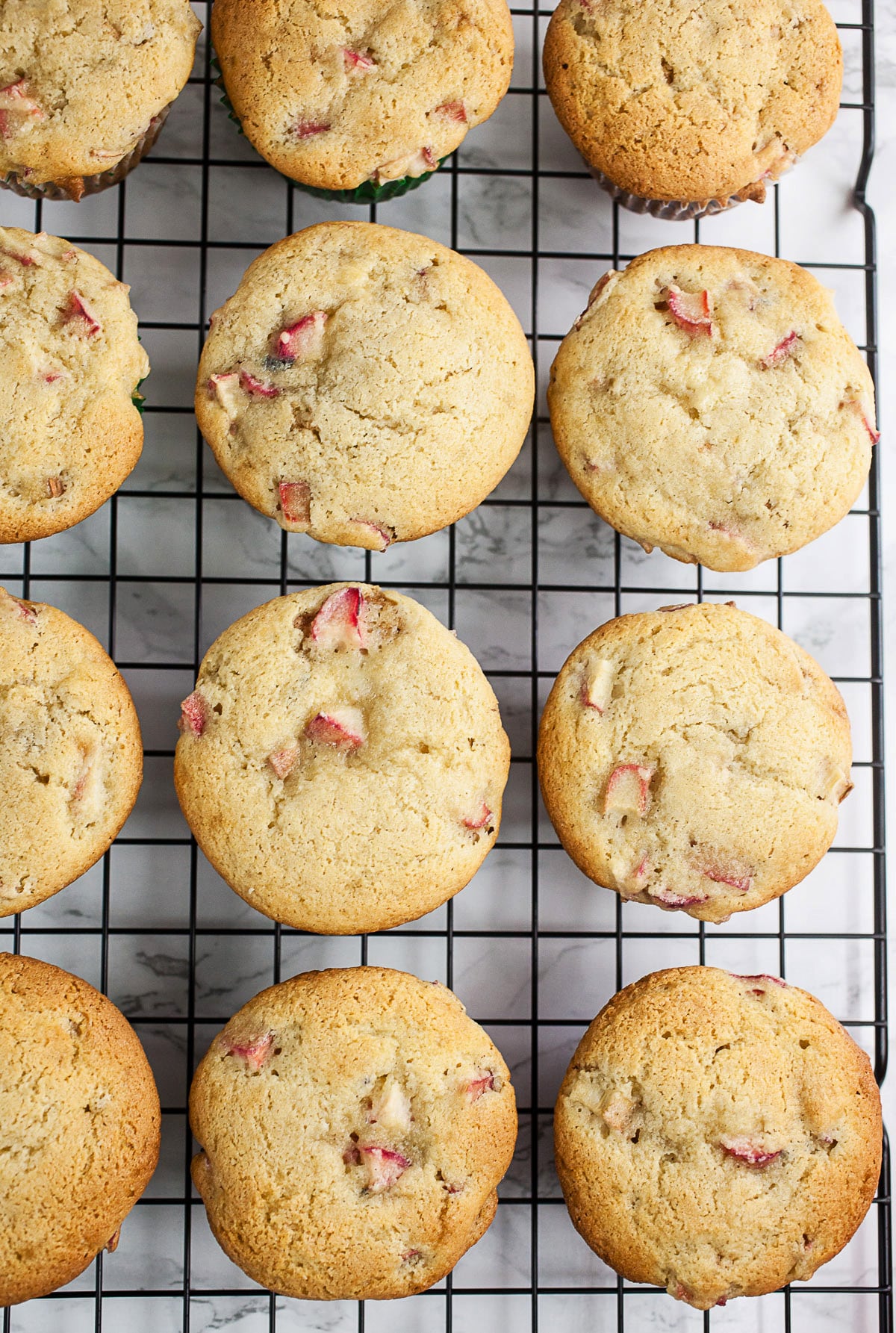 Baked rhubarb muffins on cooling rack.