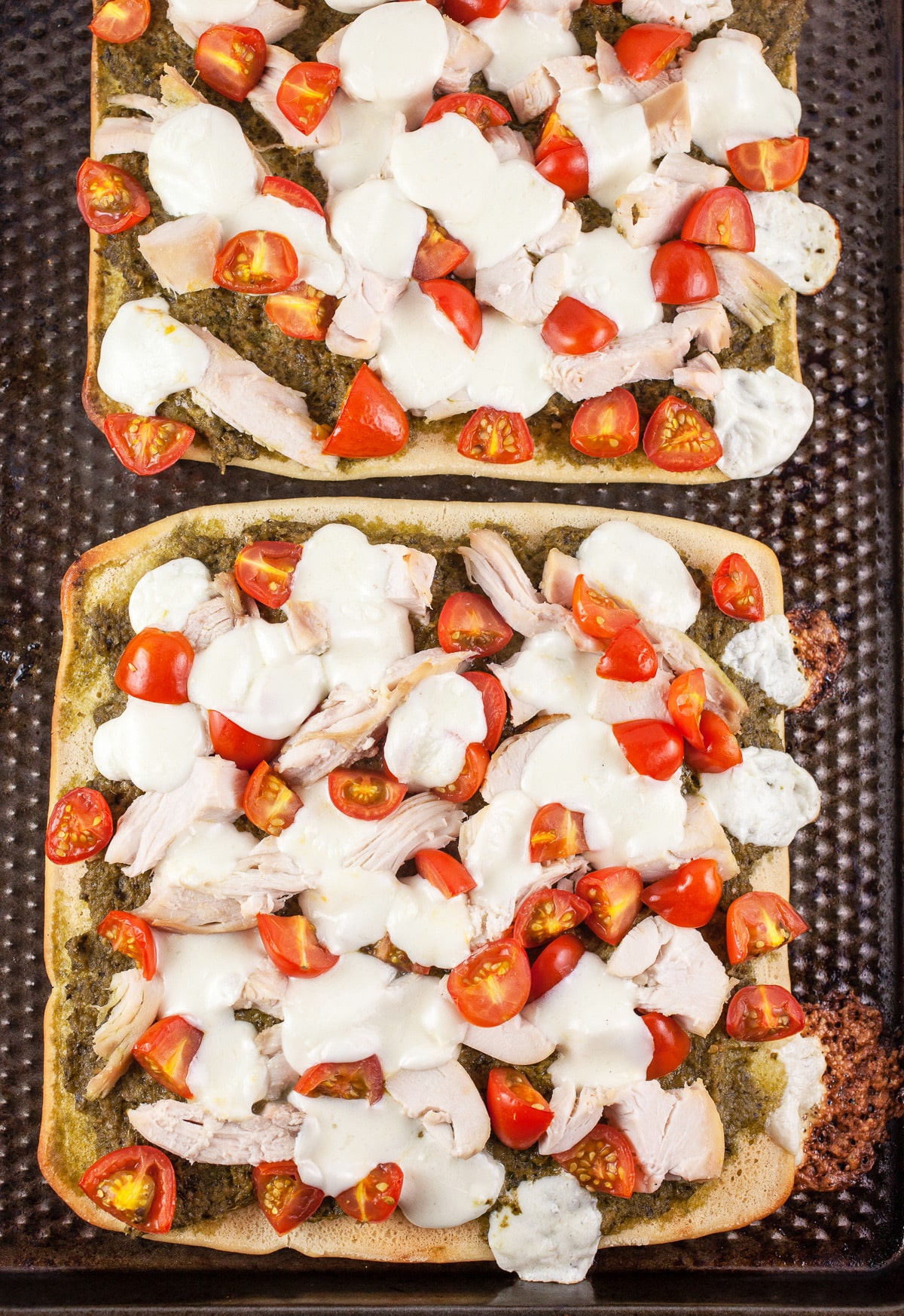 Cooked flatbread pizzas on baking sheet.
