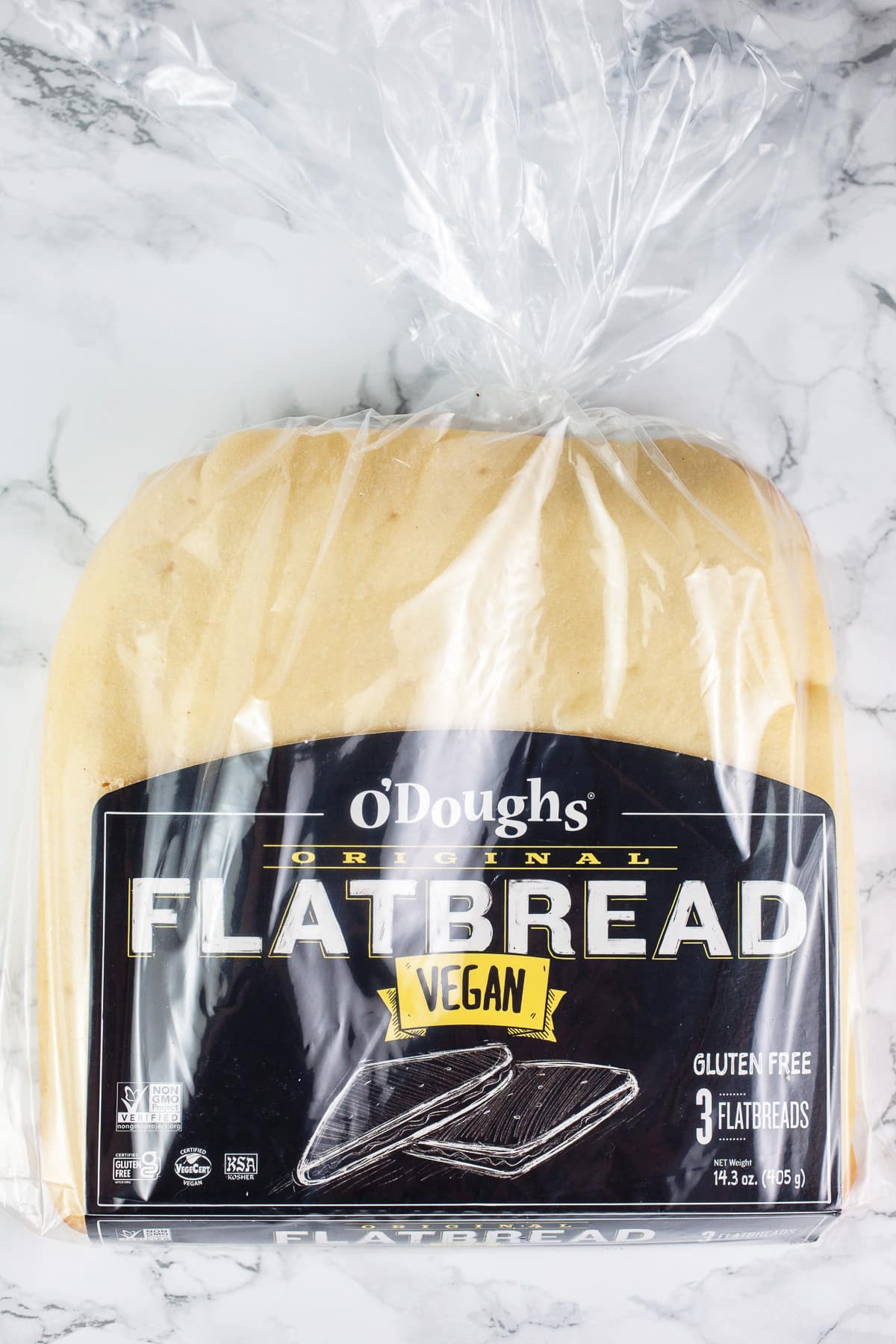 Gluten free flatbread in package on white surface.