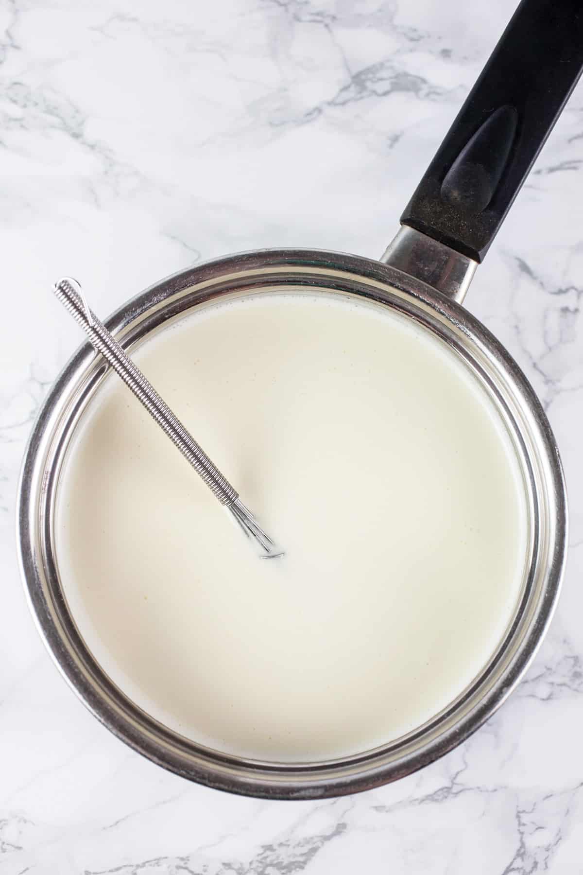 Heavy whipping cream and gelatin mixture in small sauce pan with small whisk.