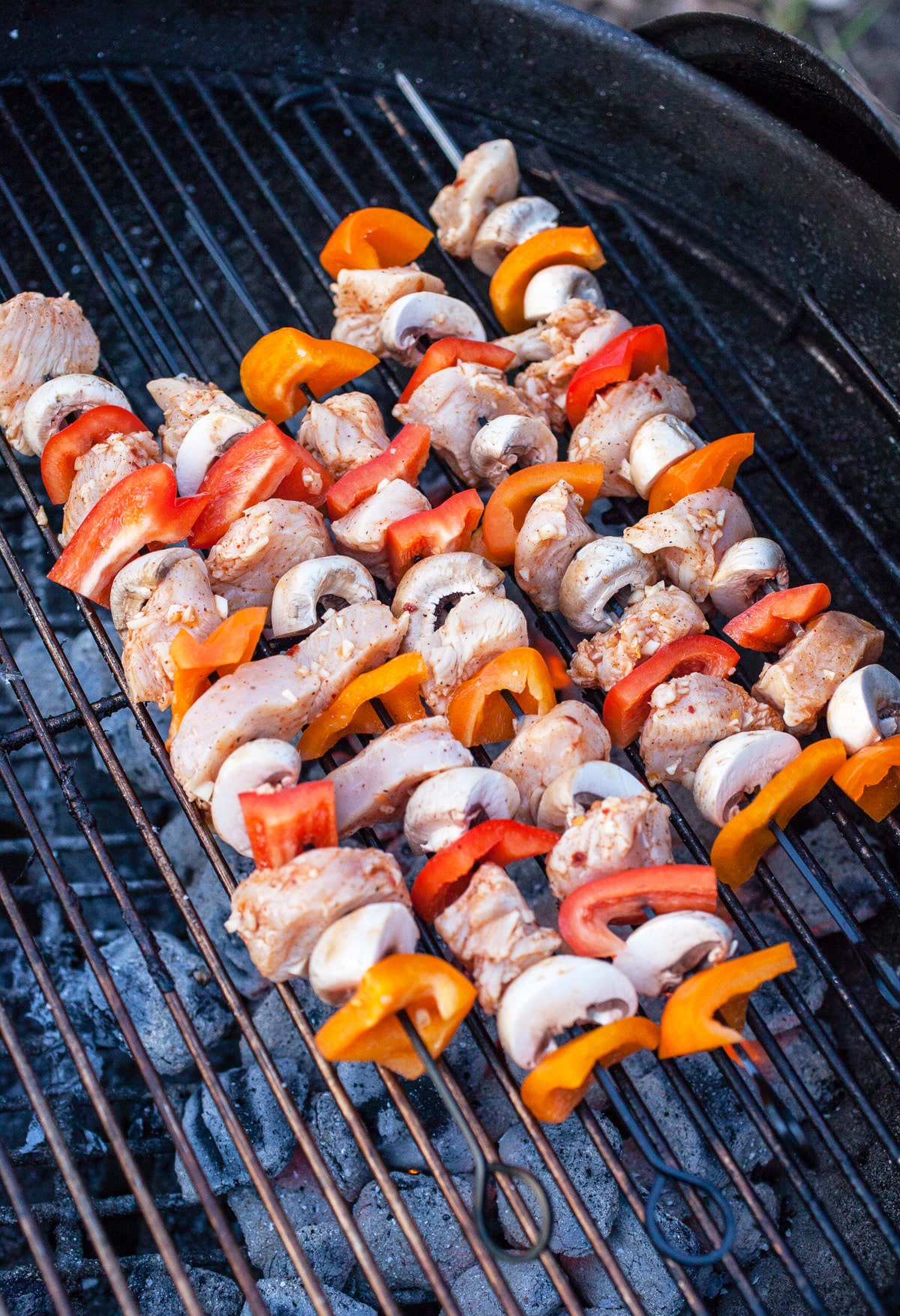Chicken and vegetable skewers on Weber charcoal grill.