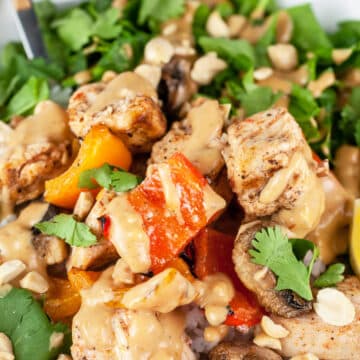 Grilled Thai chicken bowl with veggies and peanut sauce.