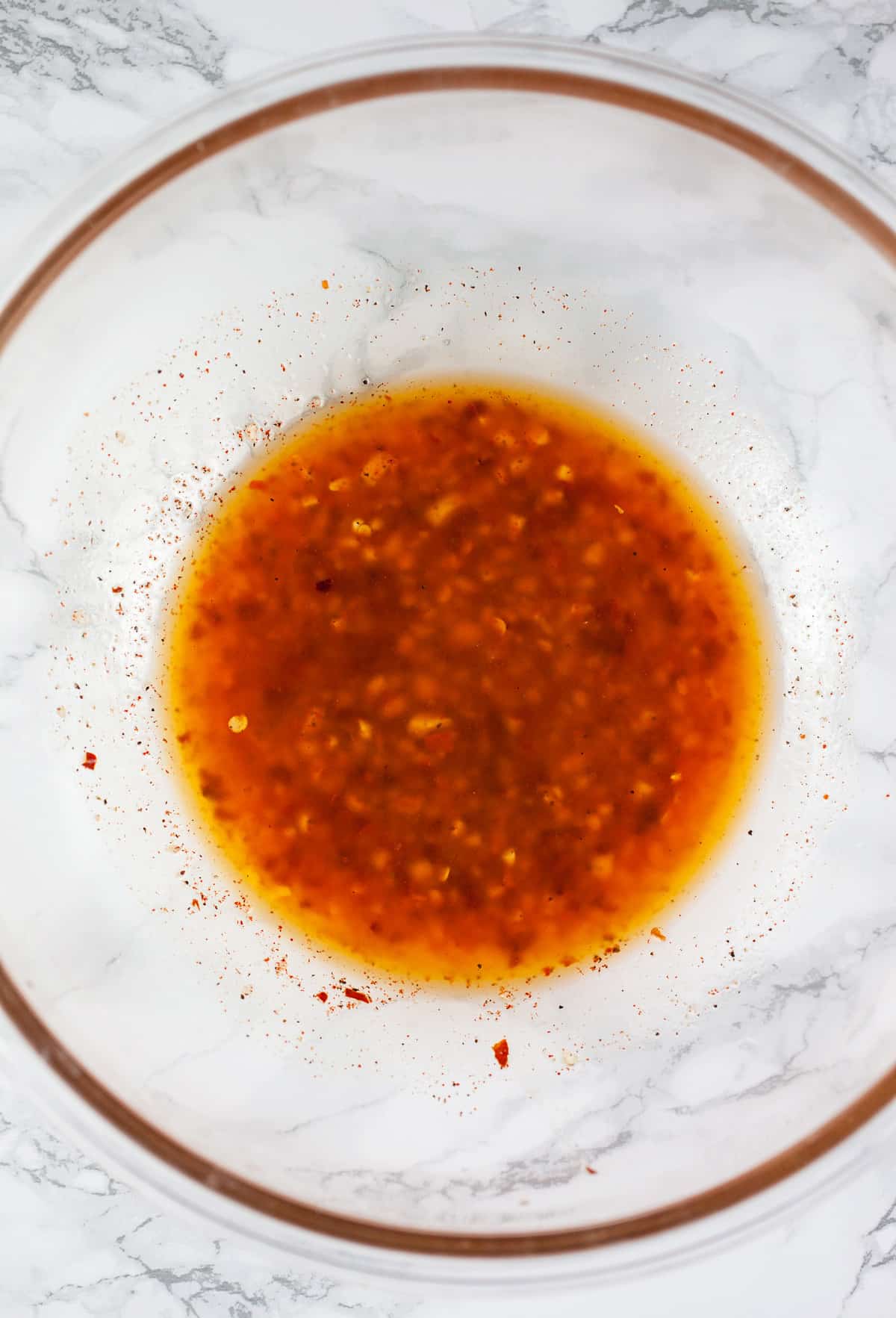 Olive oil and spices in large glass bowl.