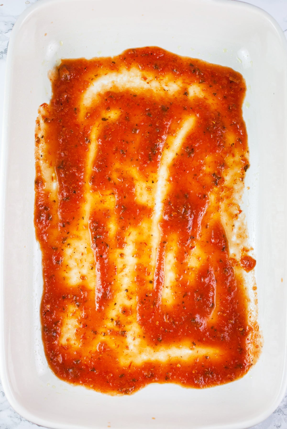 Marinara sauce in ceramic baking dish.