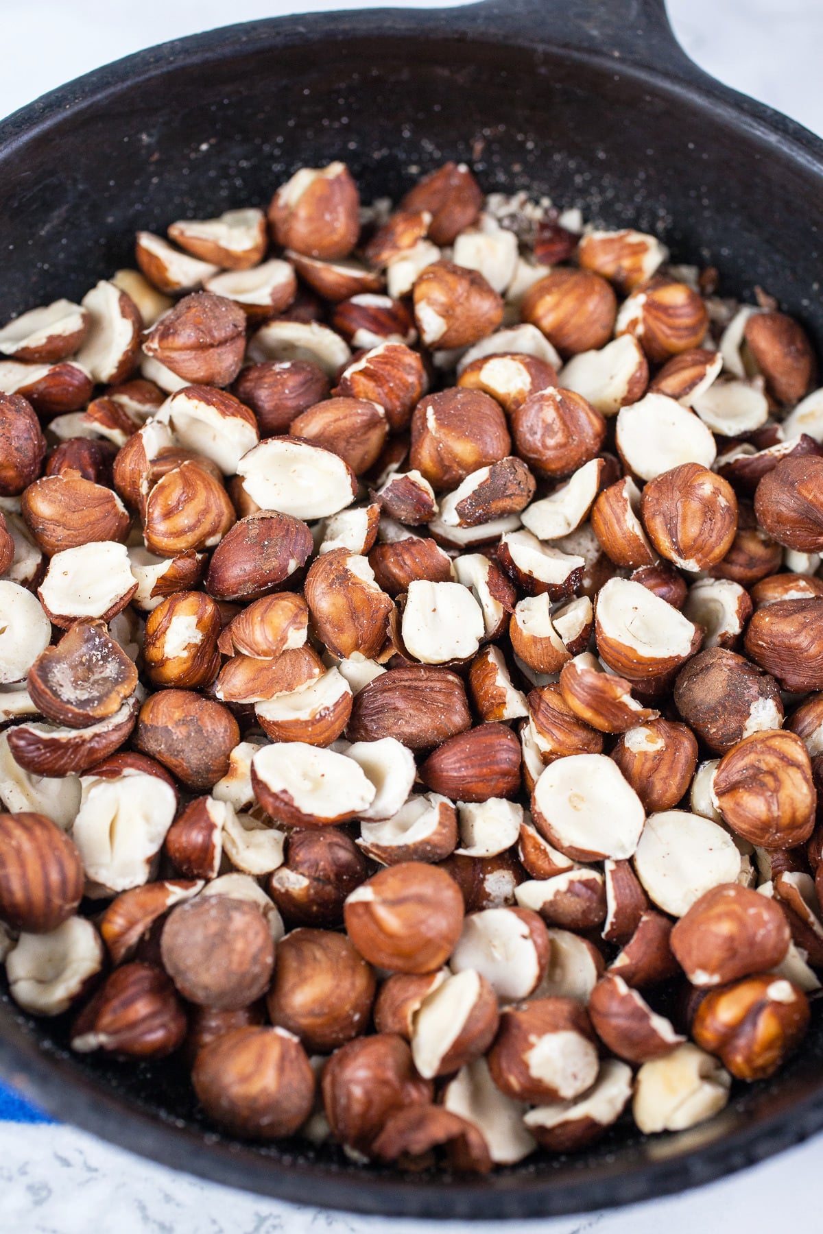 Toasted hazelnuts in small cast iron skillet.