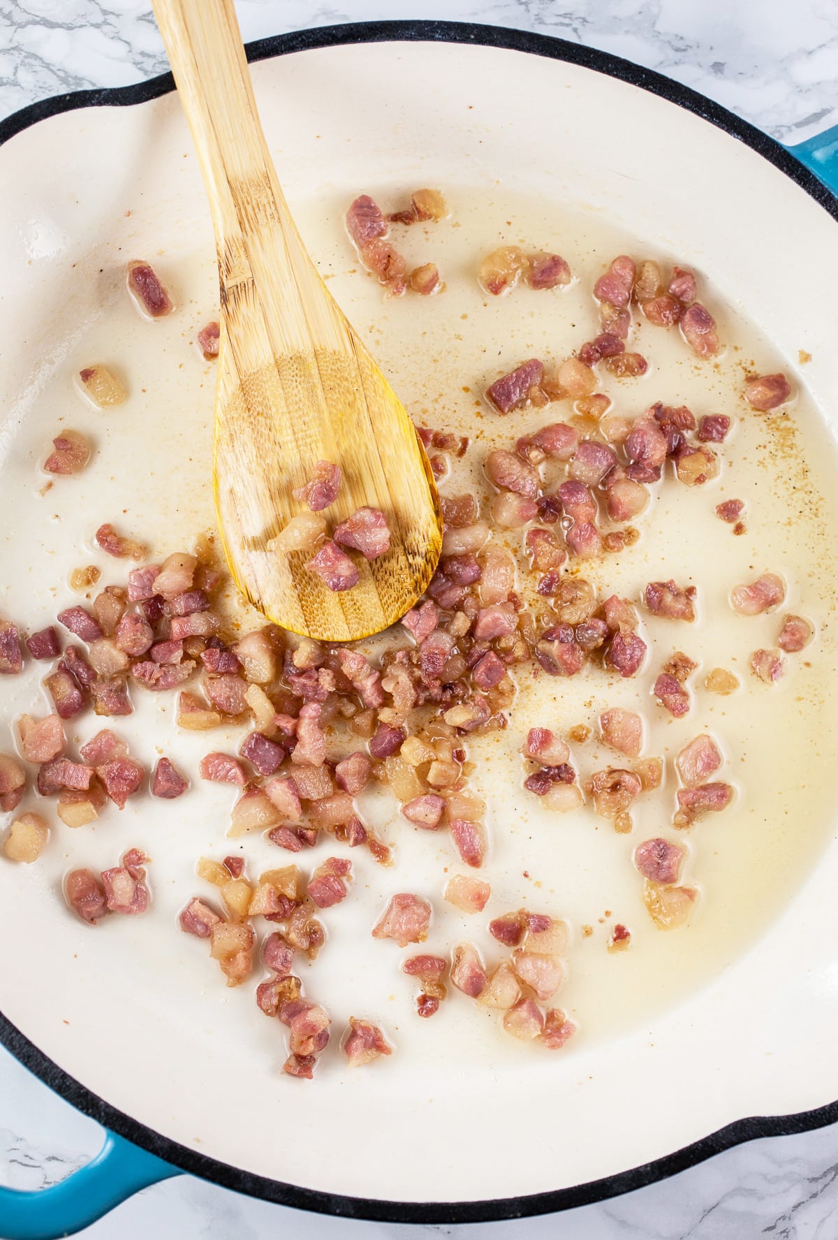 Diced pancetta sautéed in skillet.