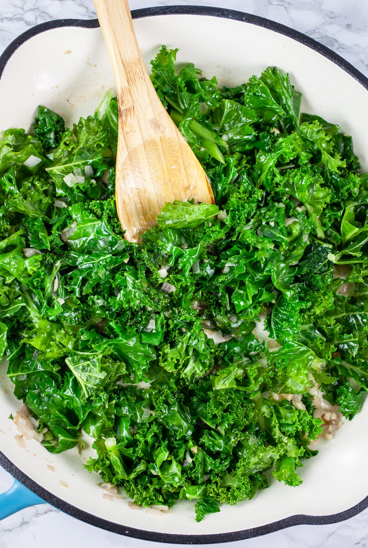 Chopped kale sautéed in skillet.