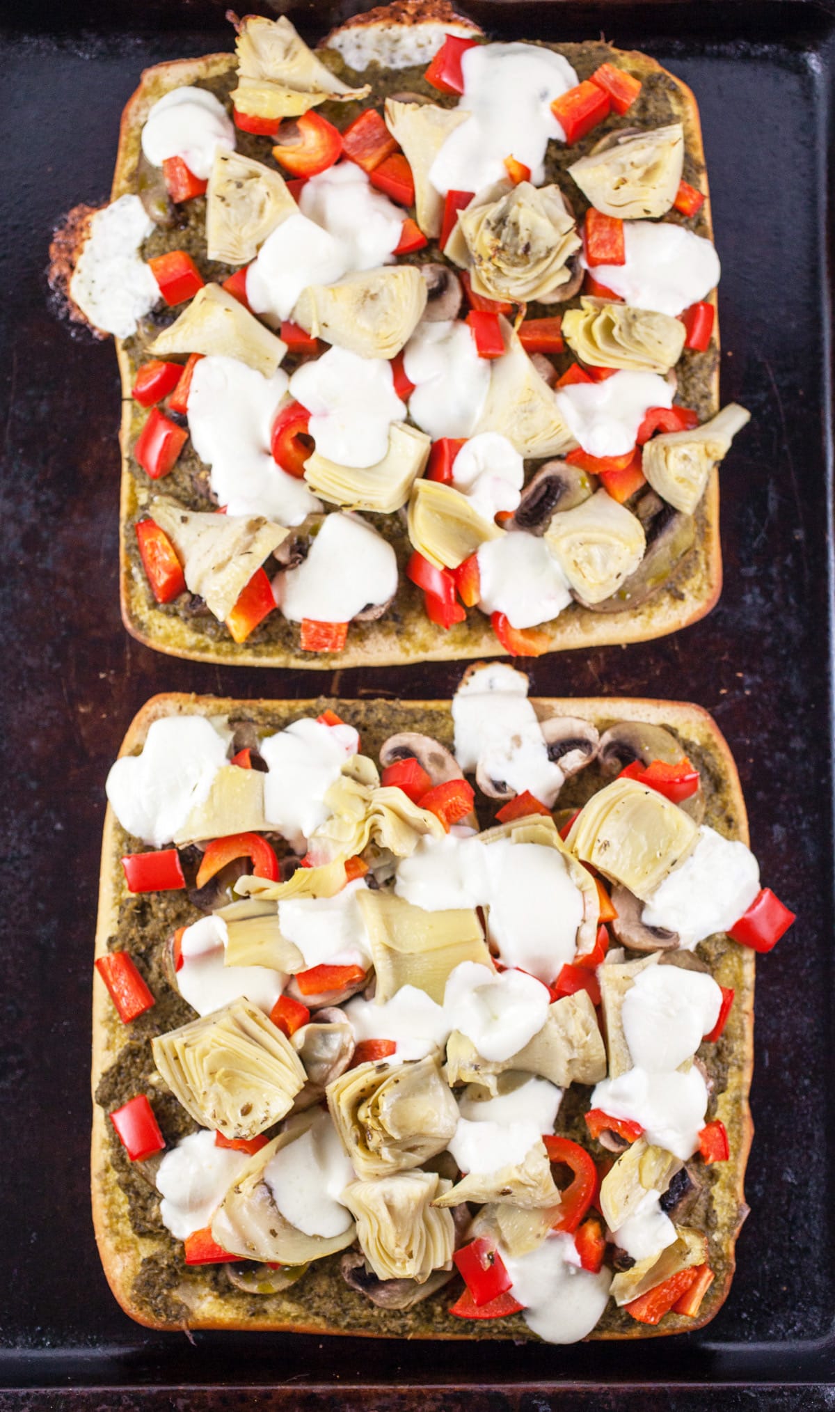 Cooked Mediterranean flatbreads on baking sheet.