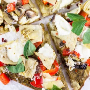 Mediterranean veggie flatbread pizza cut into slices.