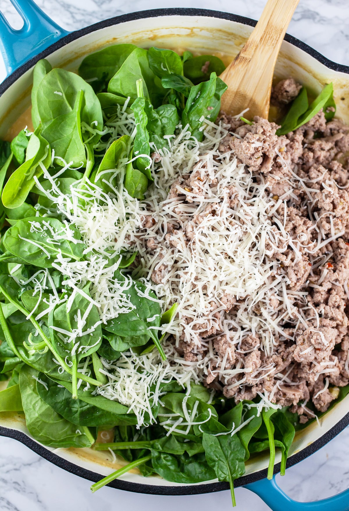 Ground turkey, spinach, and Parmesan cheese added to cooked orzo pasta in large skillet.