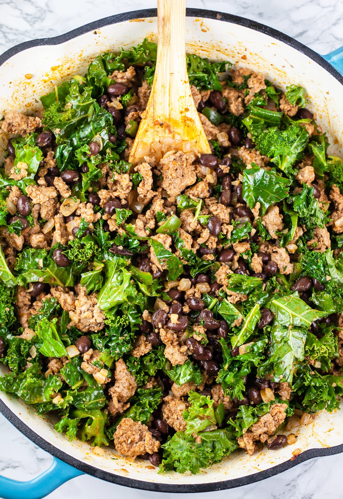 Ground turkey, kale, and black beans sautéed in skillet.