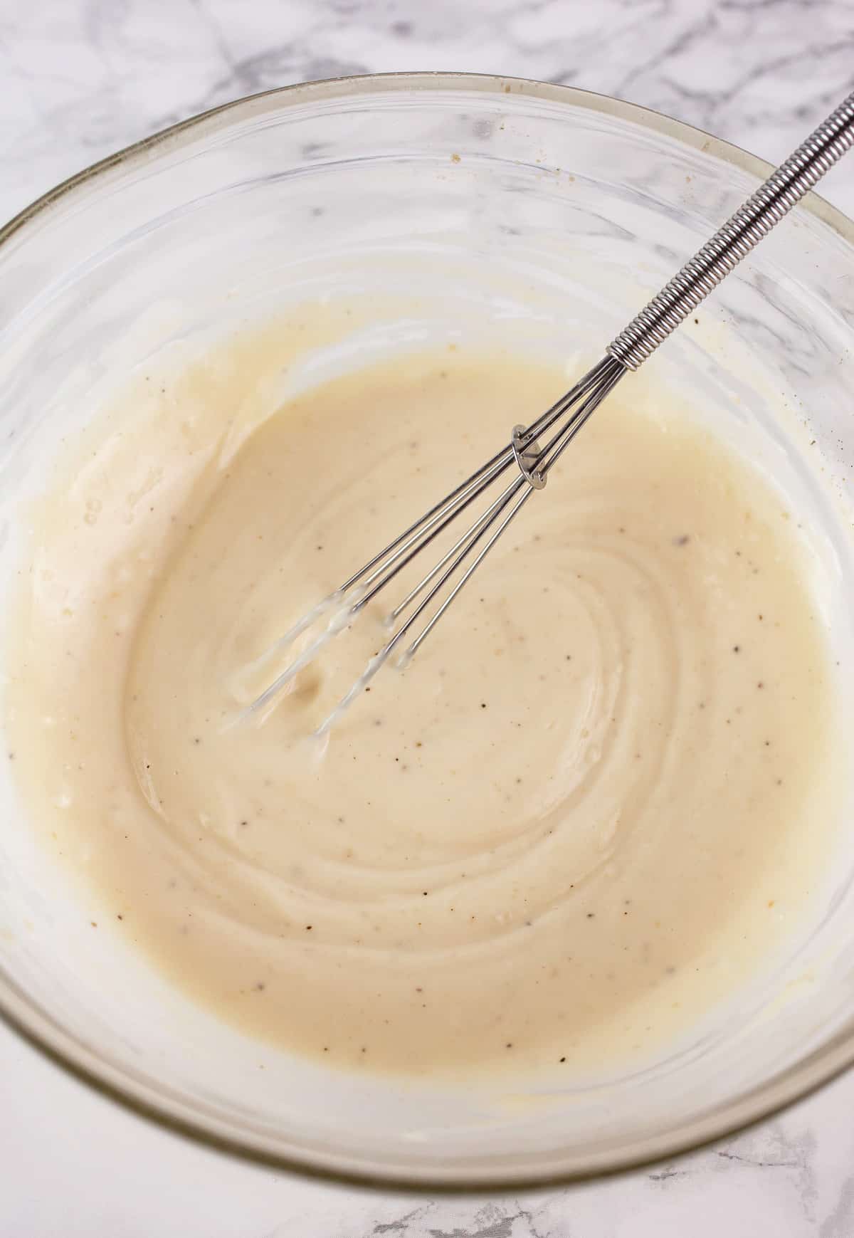 Miso mayo in small glass bowl with whisk.