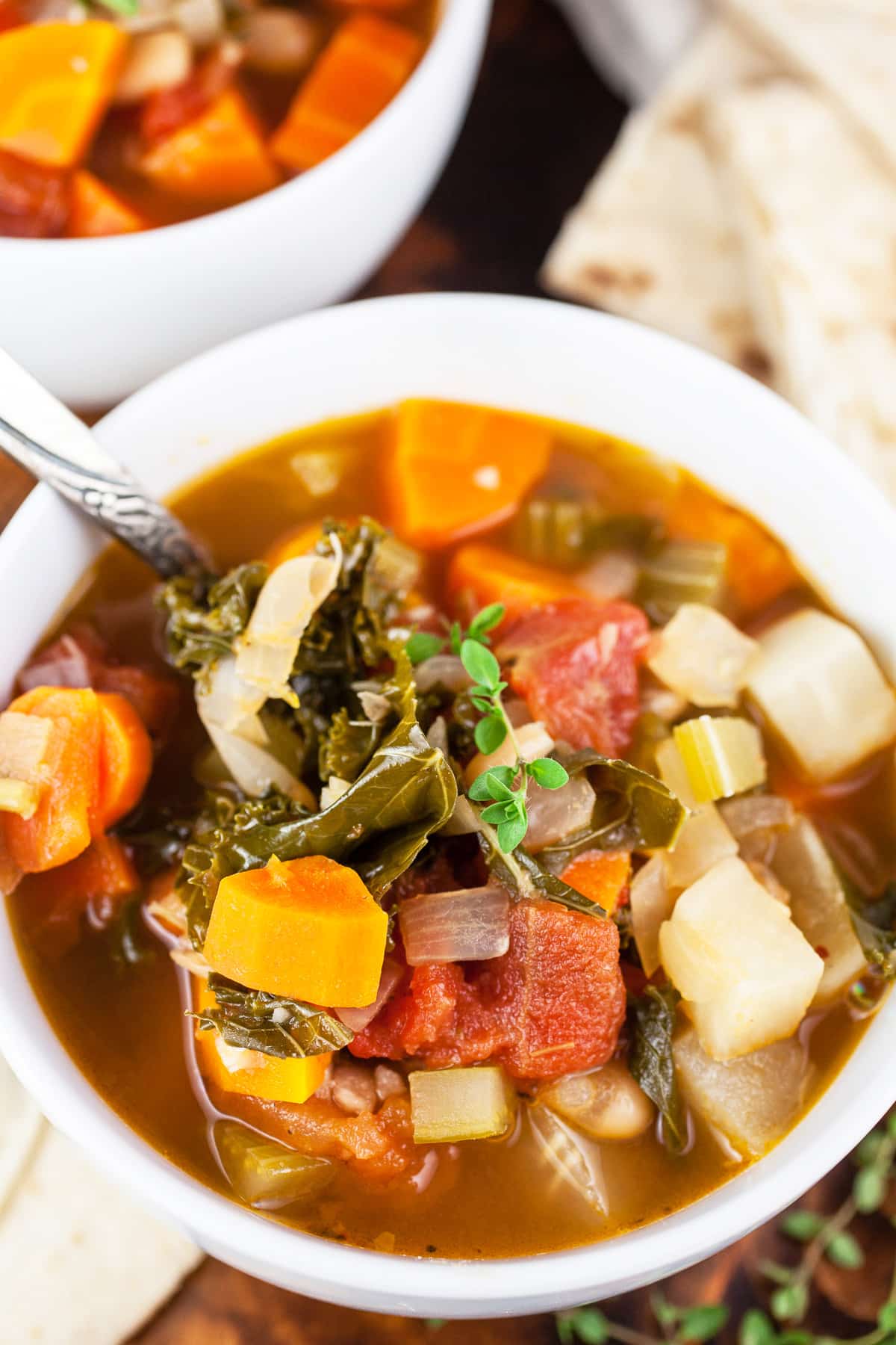 Harvest vegetable soup with pita bread in white bowls.