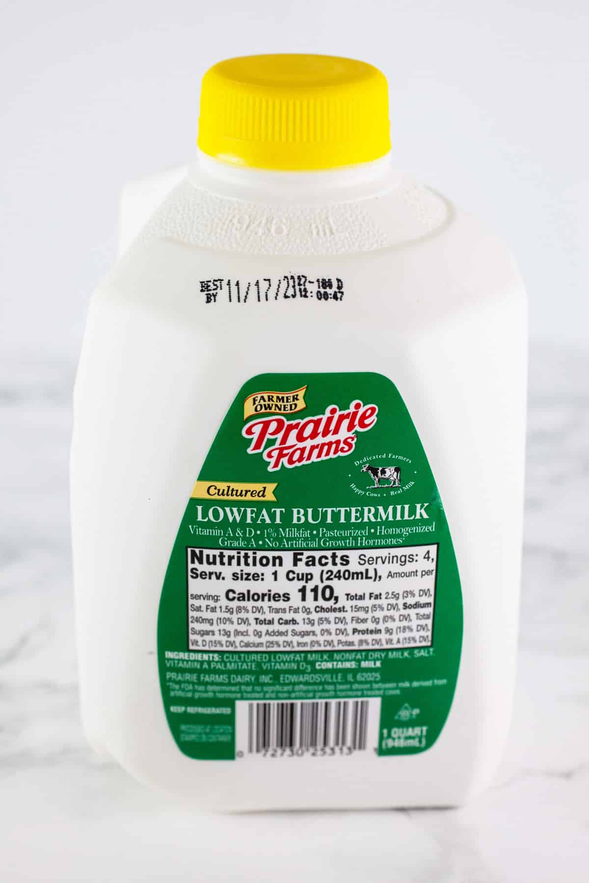 Plastic carton of buttermilk on white surface.