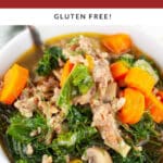 Fennel sausage kale soup in white bowl with spoon.