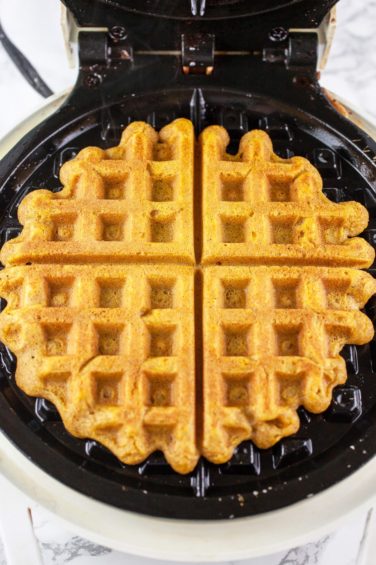 Cooked pumpkin waffle in waffle maker.