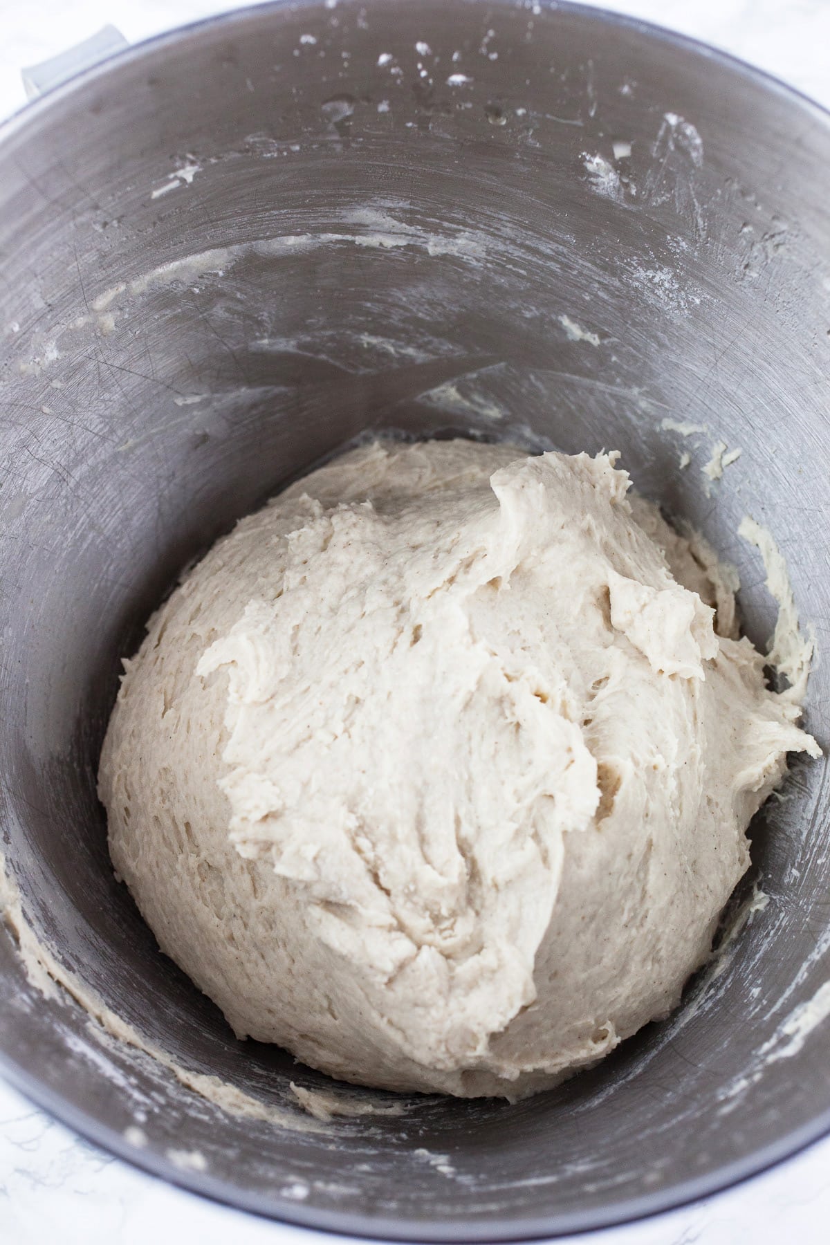 Pizza dough in stand mixer bowl.
