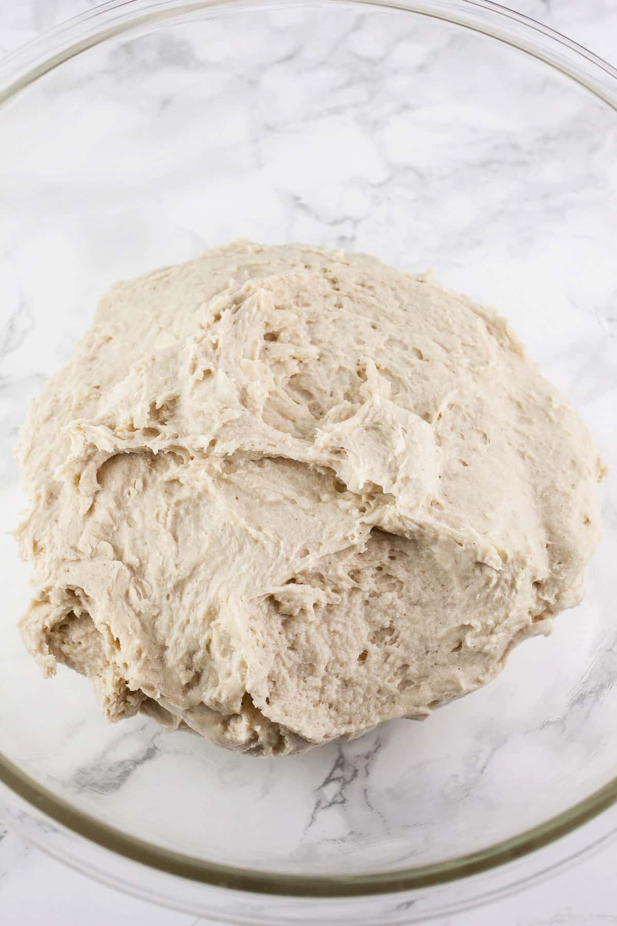 Pizza dough in large glass bowl.