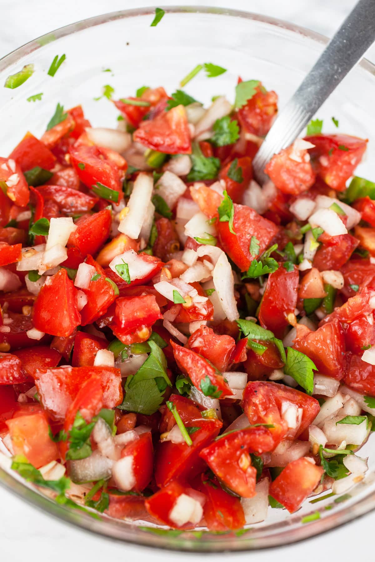 Pico de Gallo in small glass bowl with spoon.