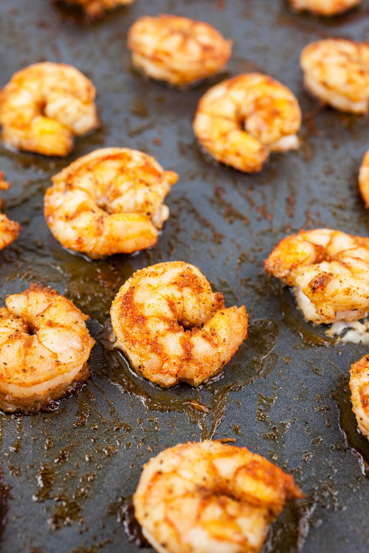 Cooked shrimp on baking sheet.